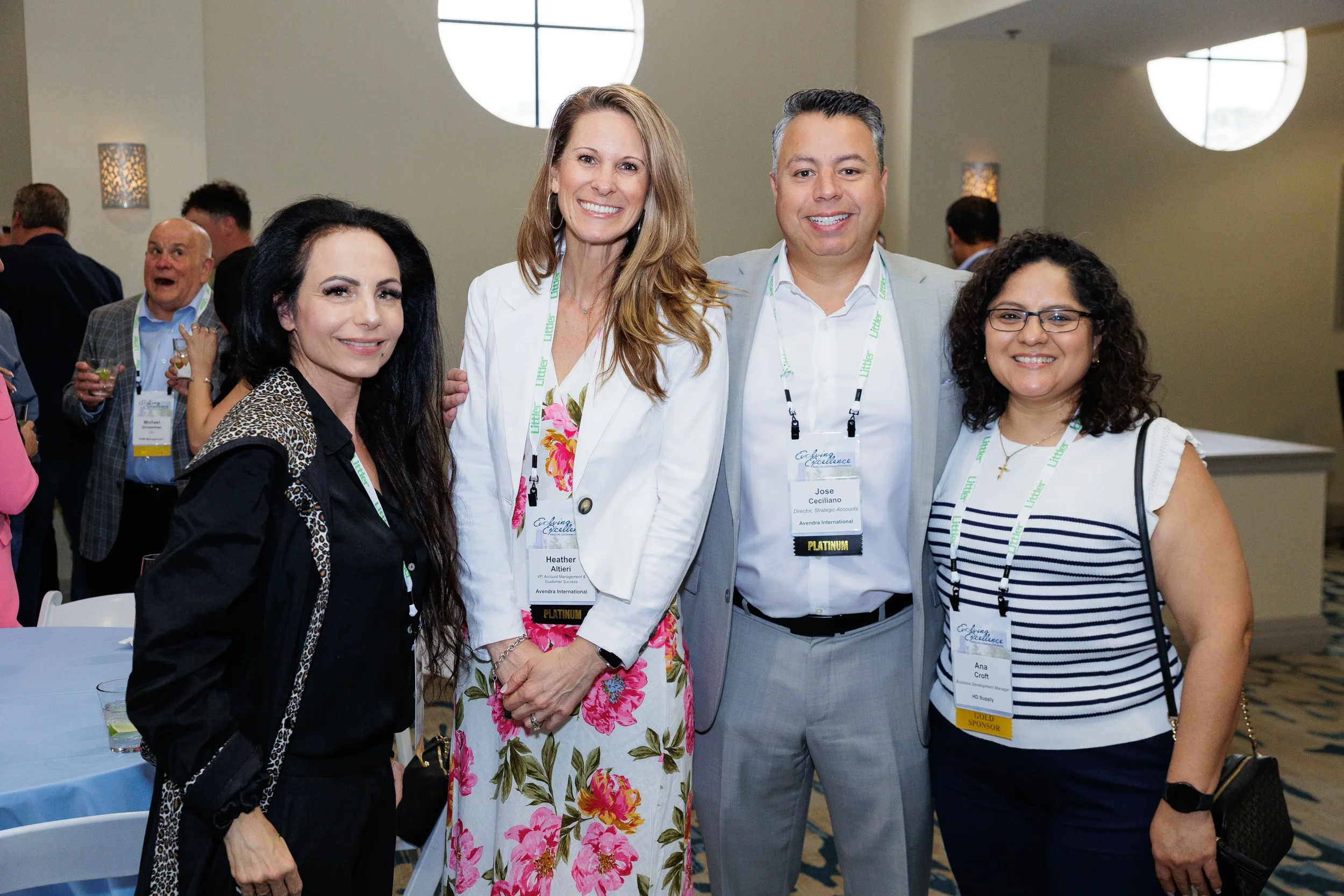 Four attendees with lanyards smile together for group photo at Orlando corporate conference reception