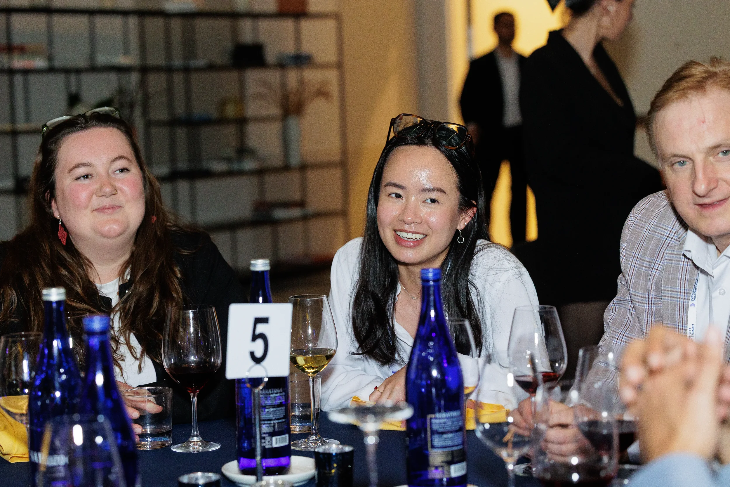 Attendees smile during conversation at seated dinner table at Chicago corporate conference banquet