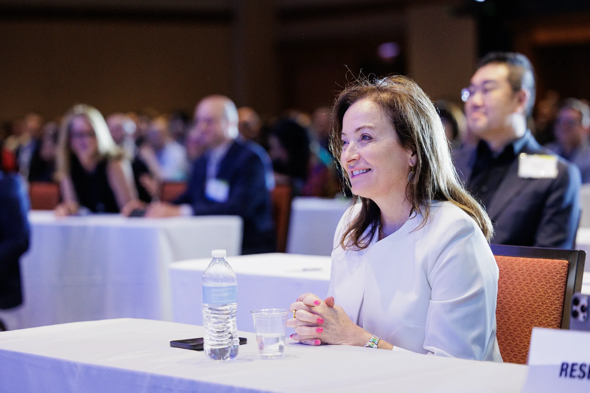 Attendee smiles while seated during conference session at Chicago industry event