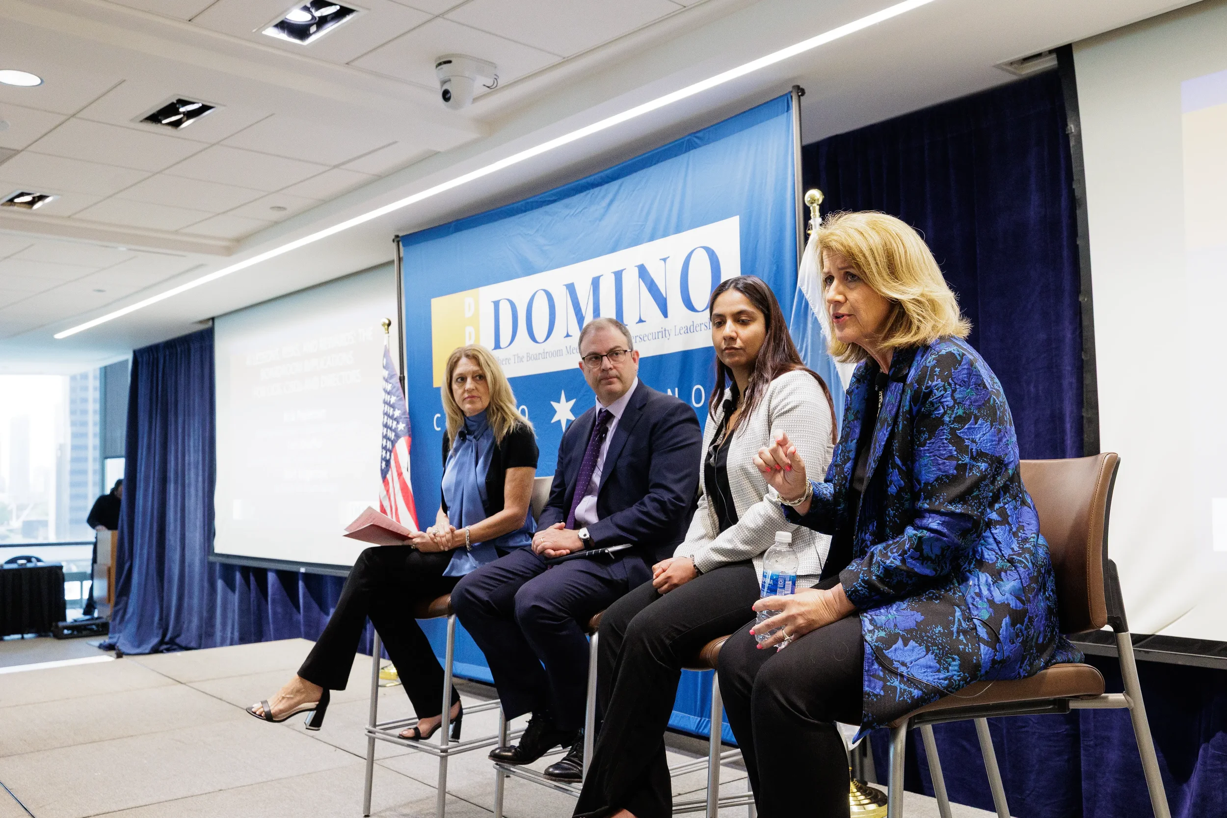 Four panelists seated on branded stage during panel discussion at Orlando industry conference