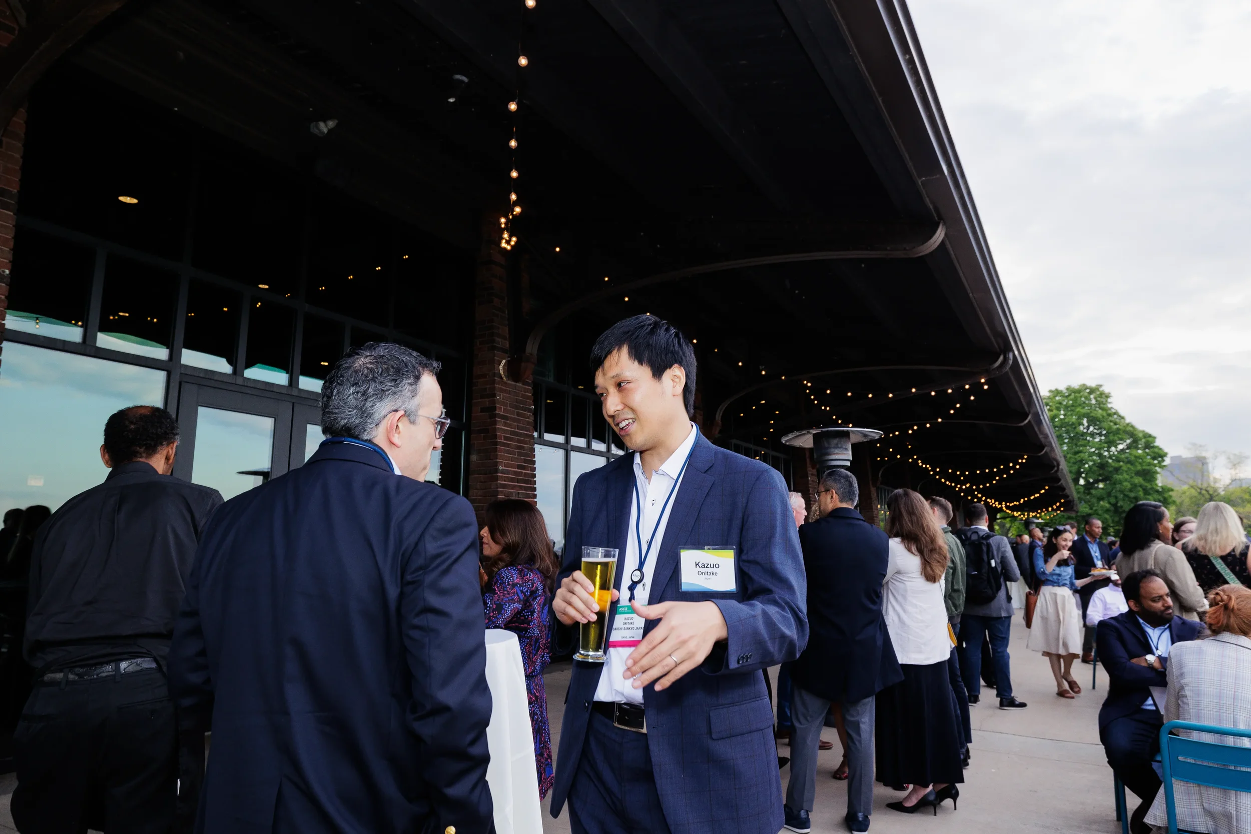 Attendees converse under string lights on outdoor patio during Orlando evening reception