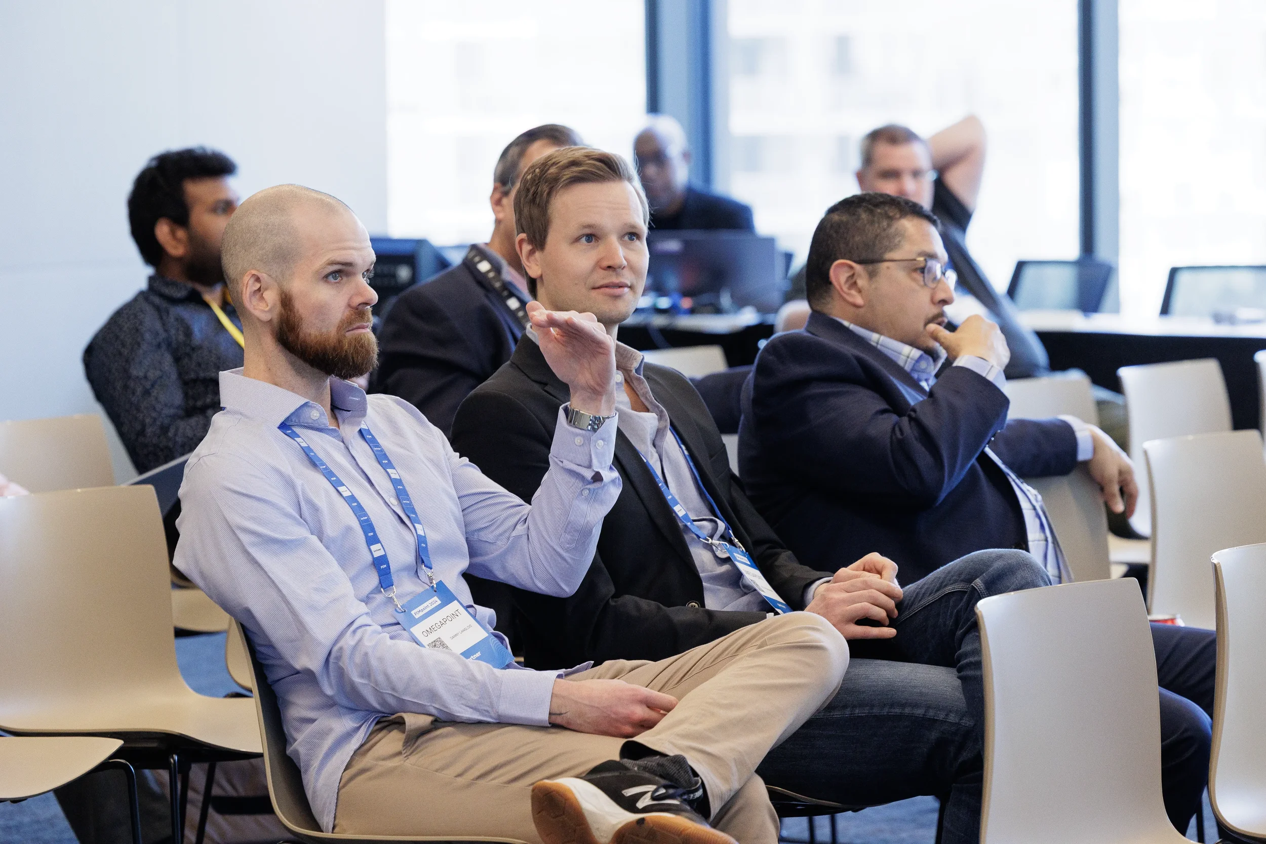Seated attendees with lanyards listen intently during breakout session at Orlando industry conference