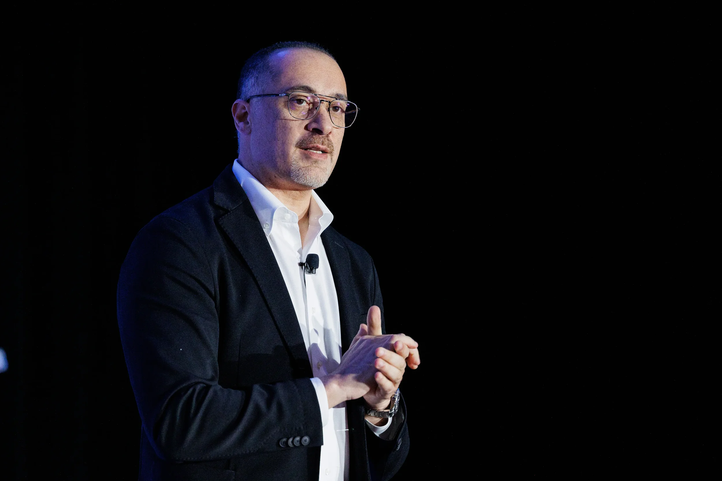 Speaker gestures while presenting on stage at Chicago corporate conference