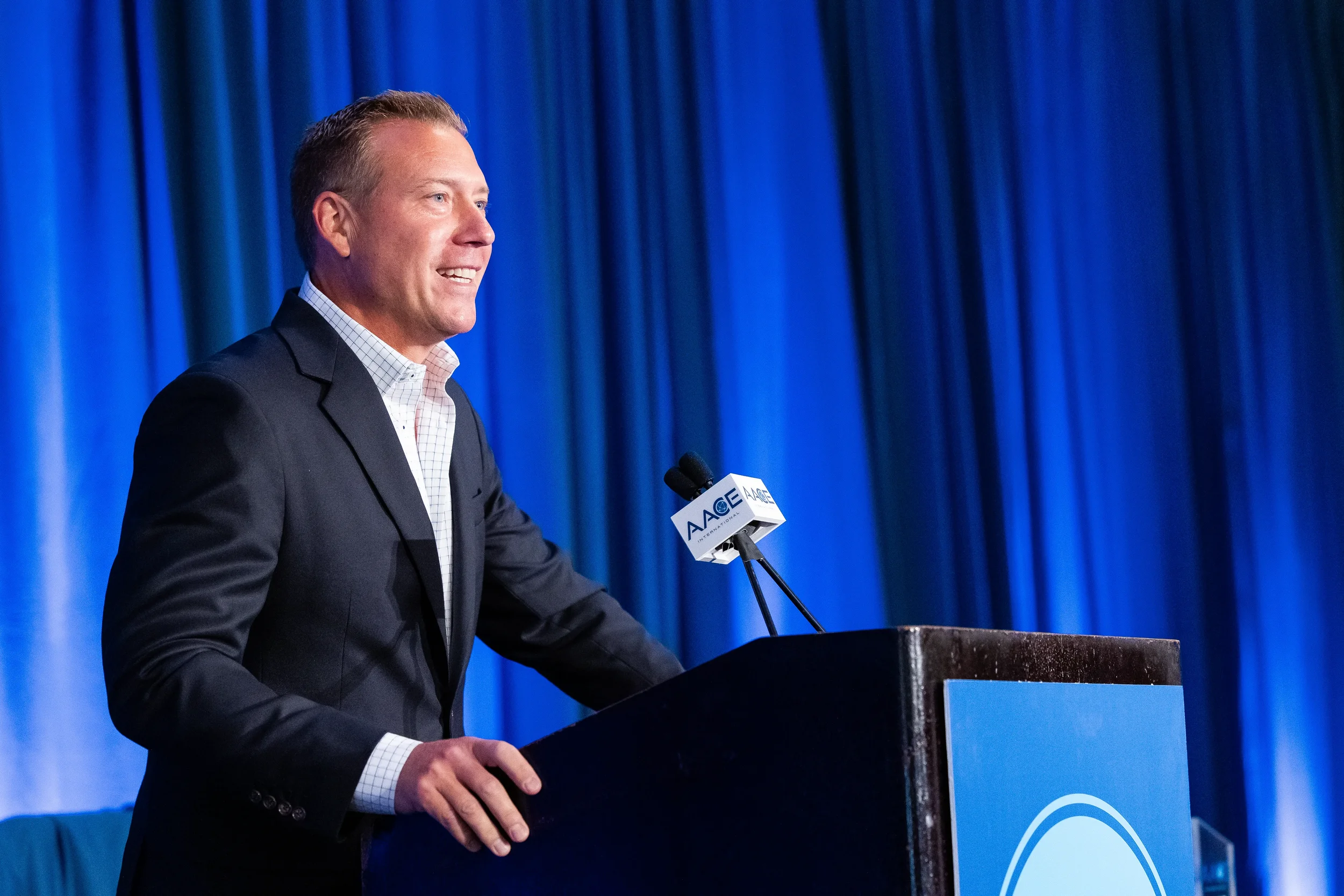 Keynote speaker smiles while addressing audience from podium at Chicago conference