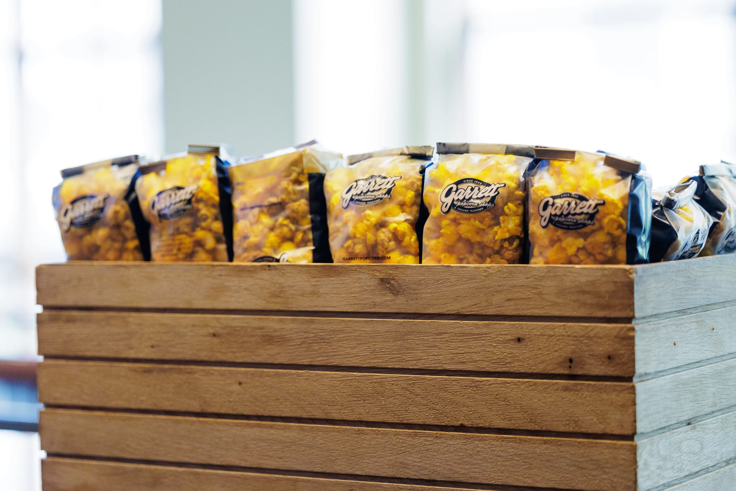 Bags of gourmet popcorn displayed in a wooden crate at Chicago corporate event