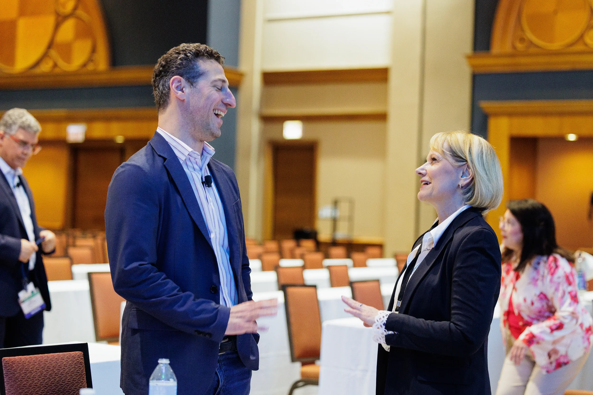 Attendees laugh during conversation in ballroom at Orlando corporate conference