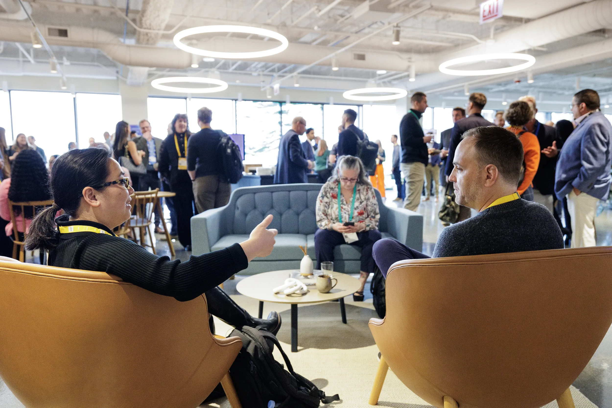 Attendees converse in lounge armchairs as guests mingle during networking reception at Chicago corporate event