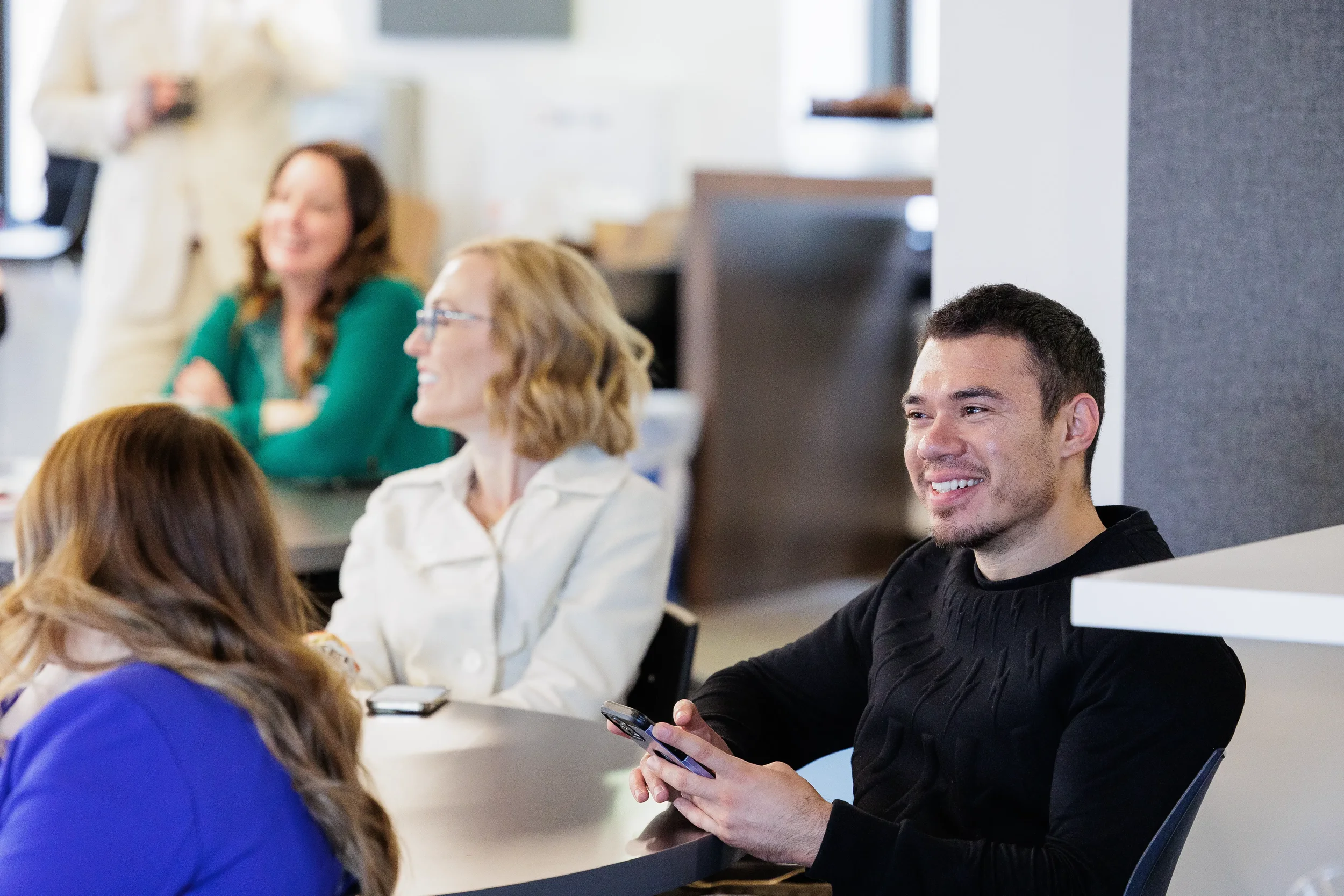 Smiling attendees seated at a table engage with a presentation at Orlando industry conference