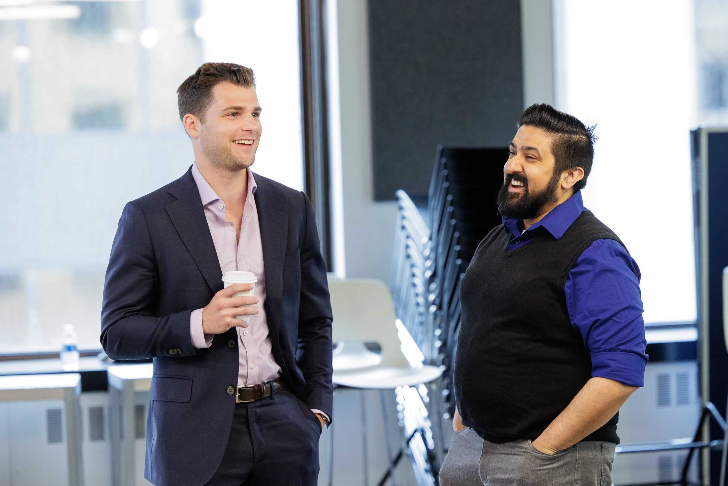wo male attendees share a laugh together with coffee during a networking break at Chicago conference