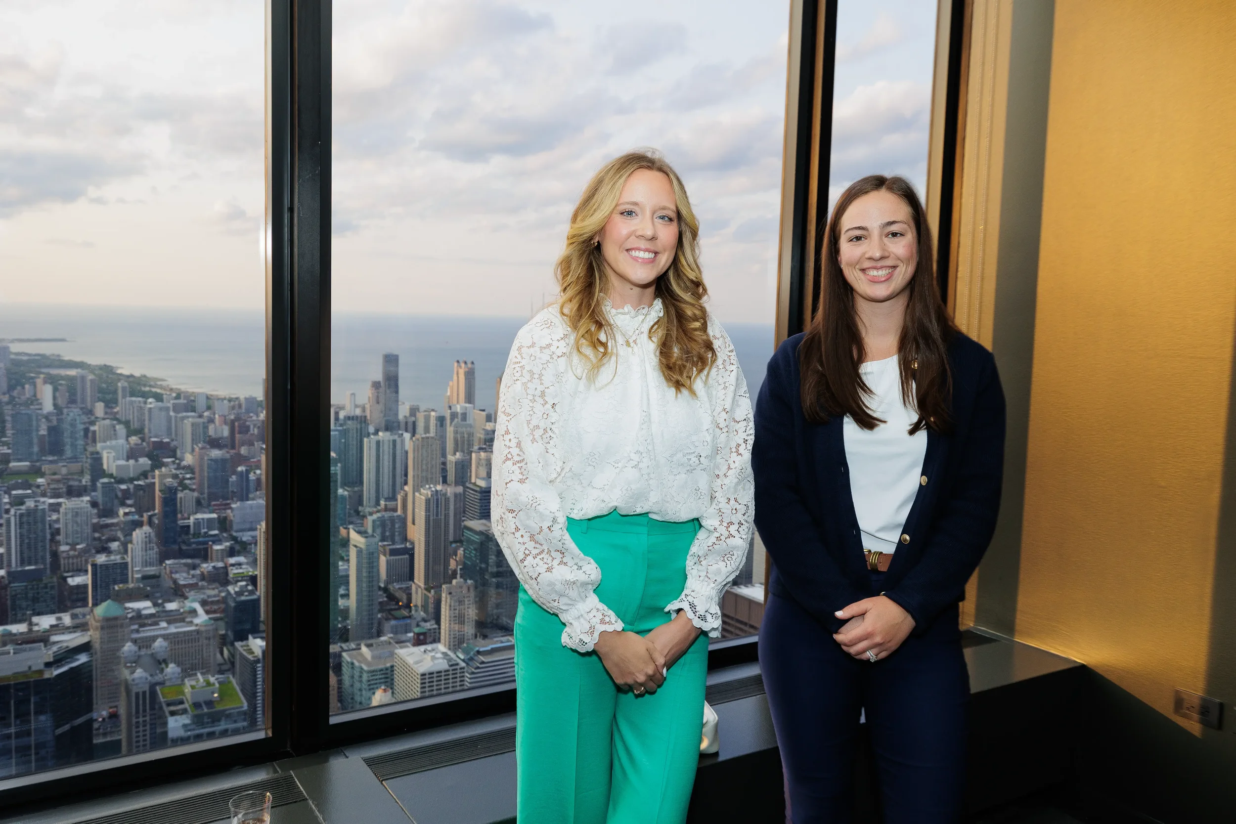 Two attendees pose together with skyline view during Orlando corporate event reception