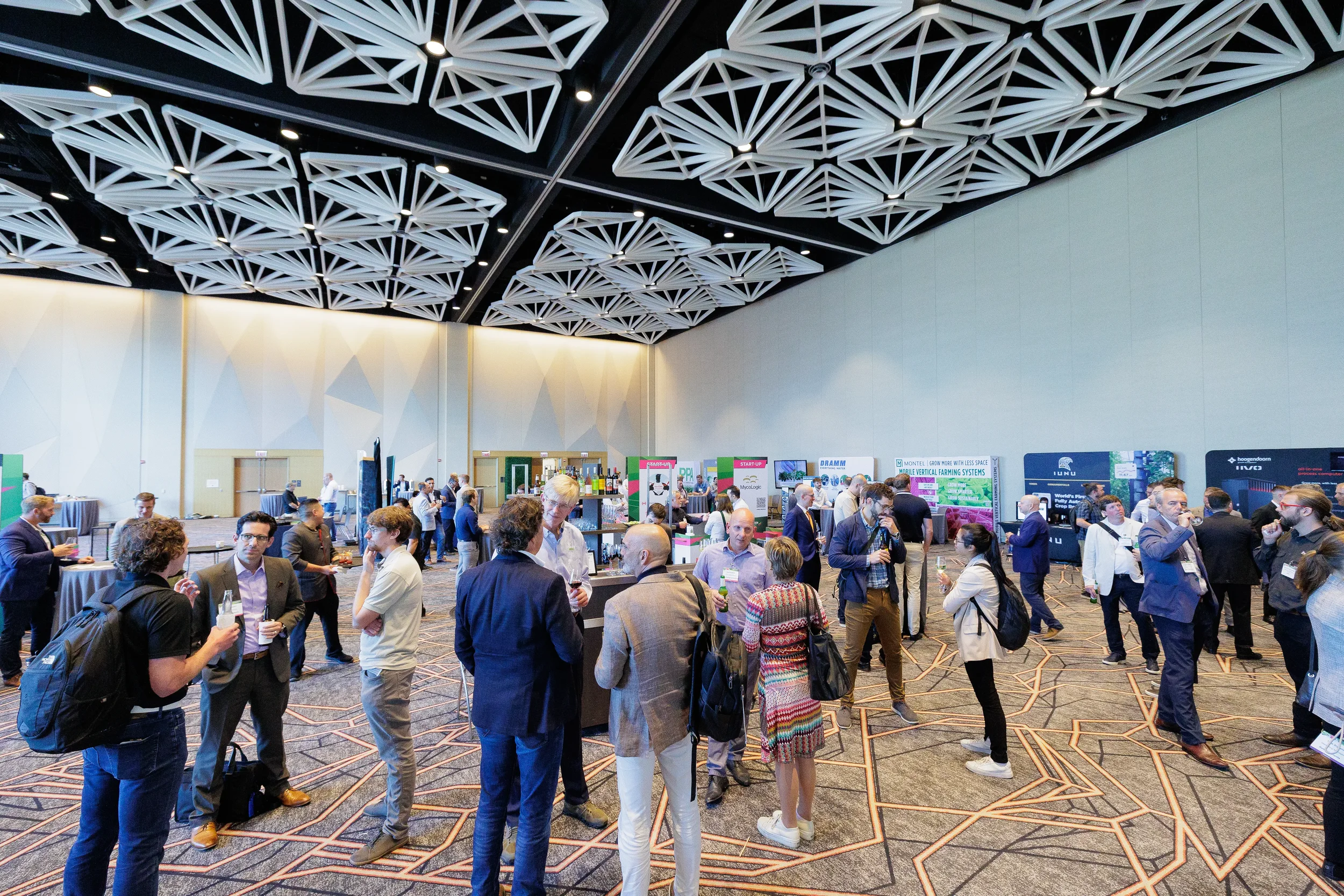 Conference attendees network among exhibitor booths during reception on Chicago expo floor