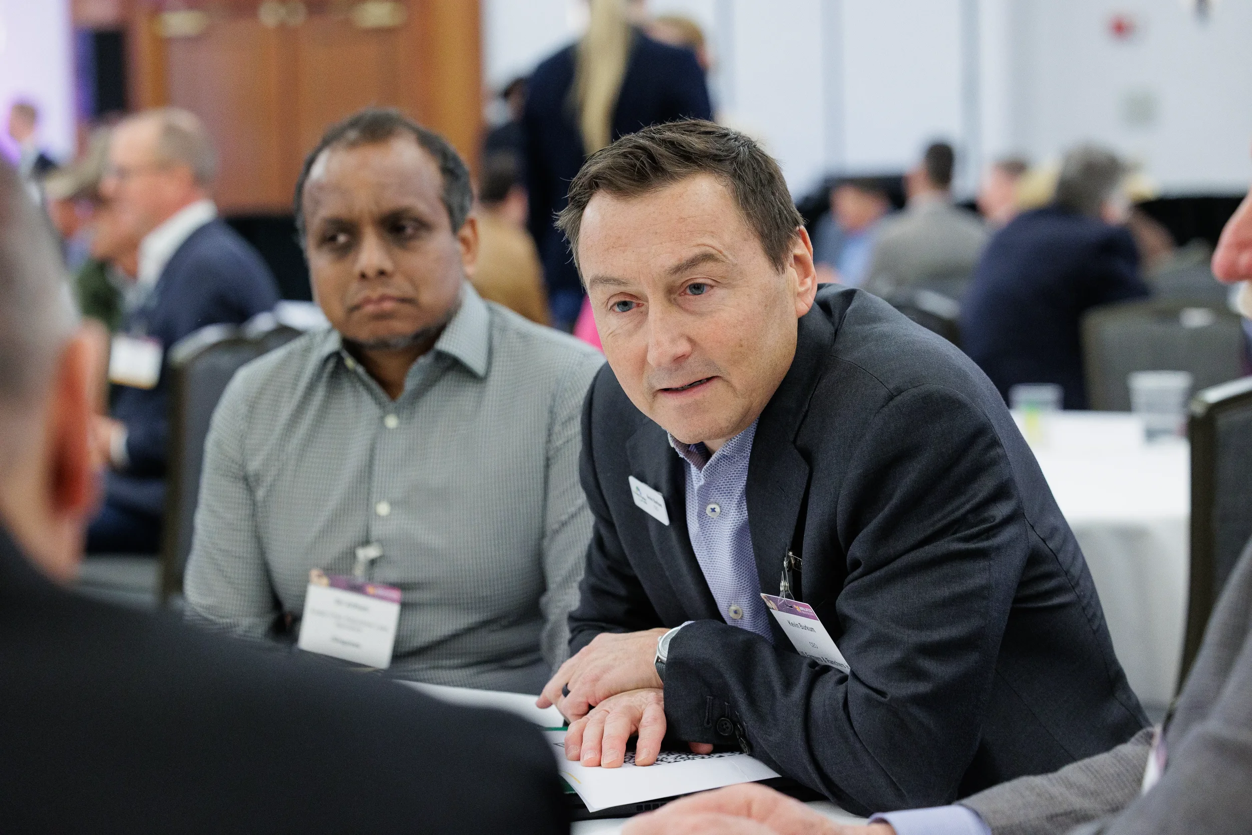 Attendee leans forward while speaking during roundtable discussion at Chicago industry conference