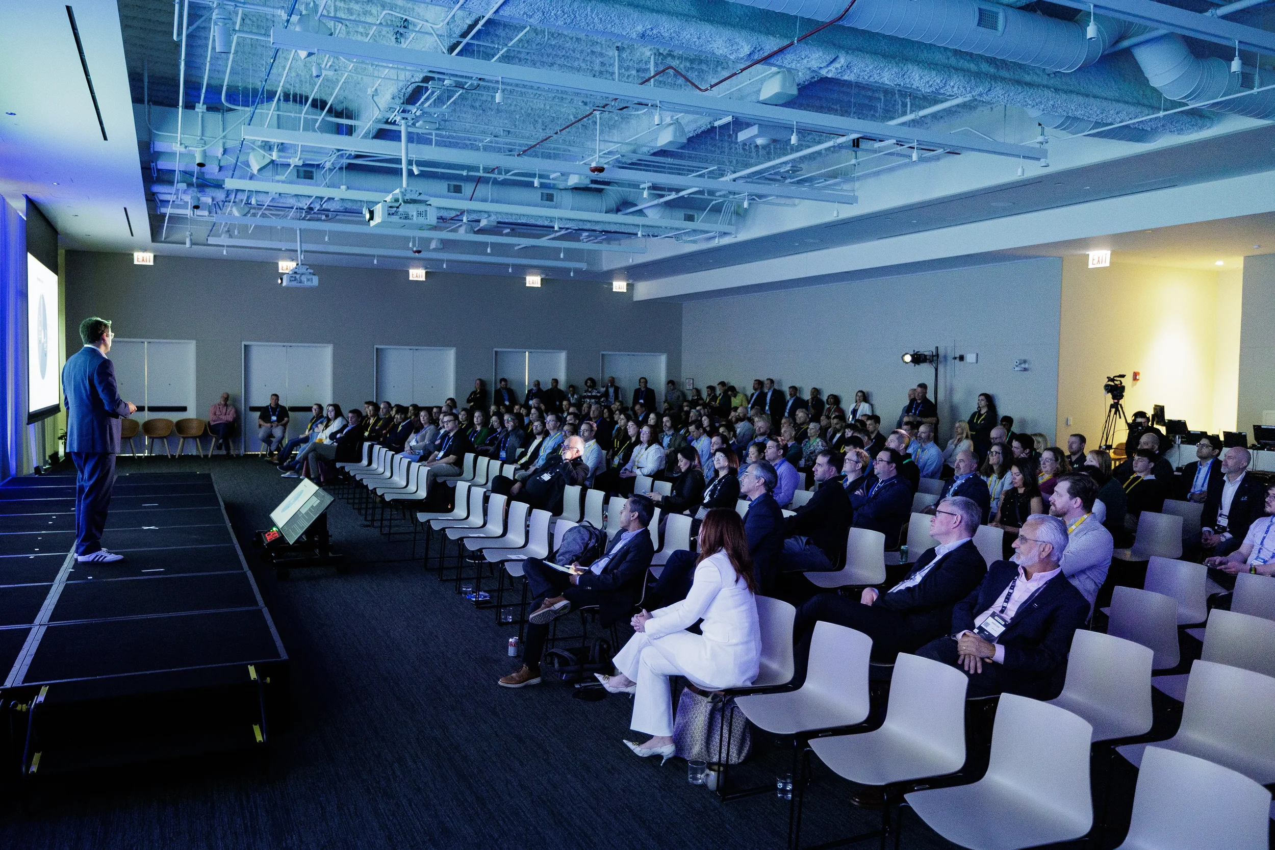 Packed audience watches presenter on stage during session at Orlando corporate conference