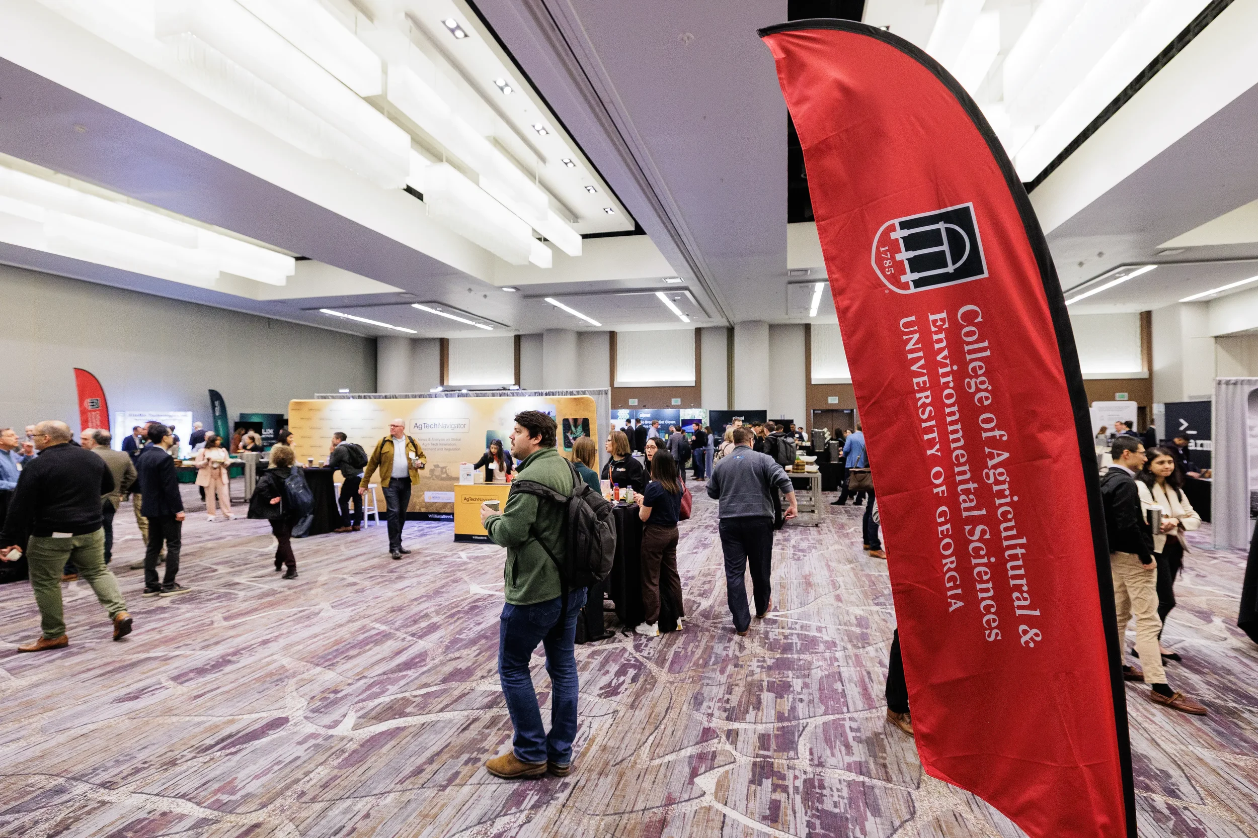 Attendees browse exhibitor booths on busy trade show expo floor at Chicago industry conference