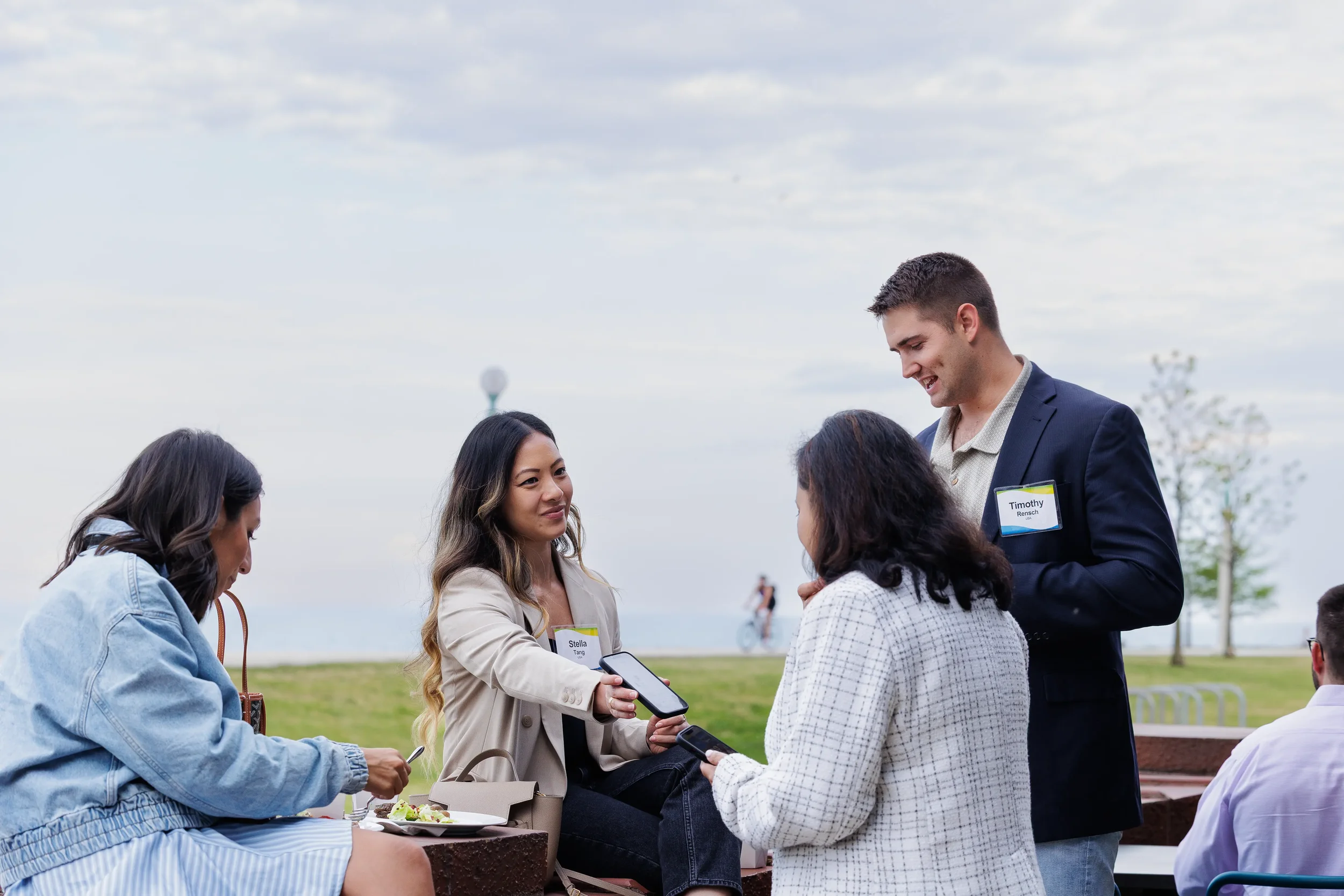 Attendees network and converse outdoors near the lakefront during Chicago industry conference