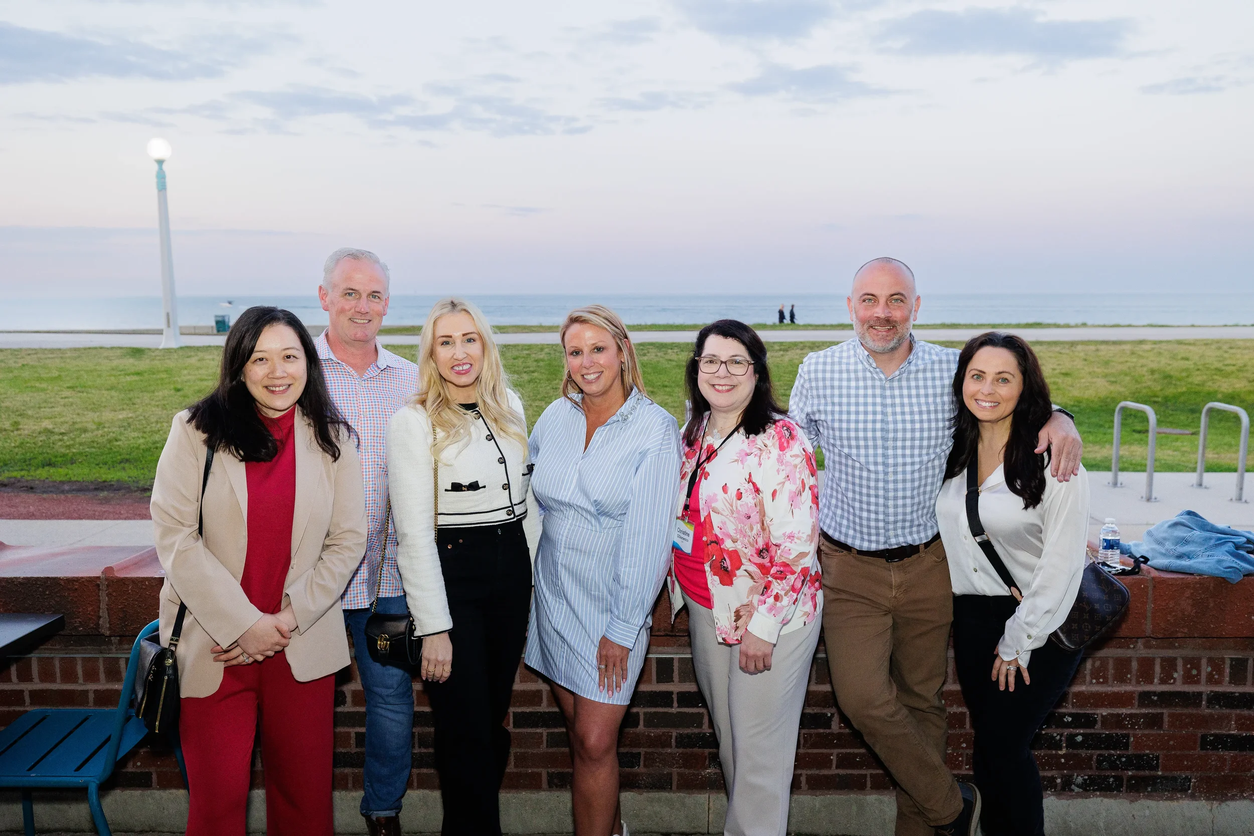 Group of attendees pose together outdoors during Orlando corporate event reception