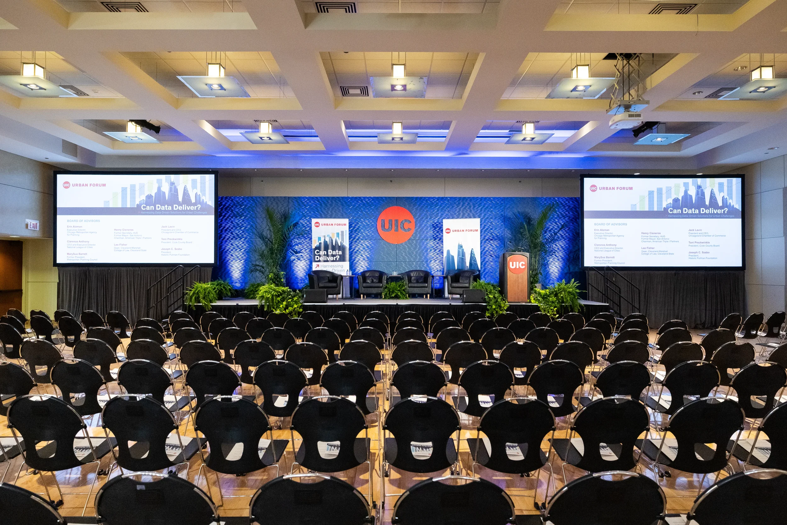Empty auditorium with rows of chairs faces branded stage before Chicago corporate conference