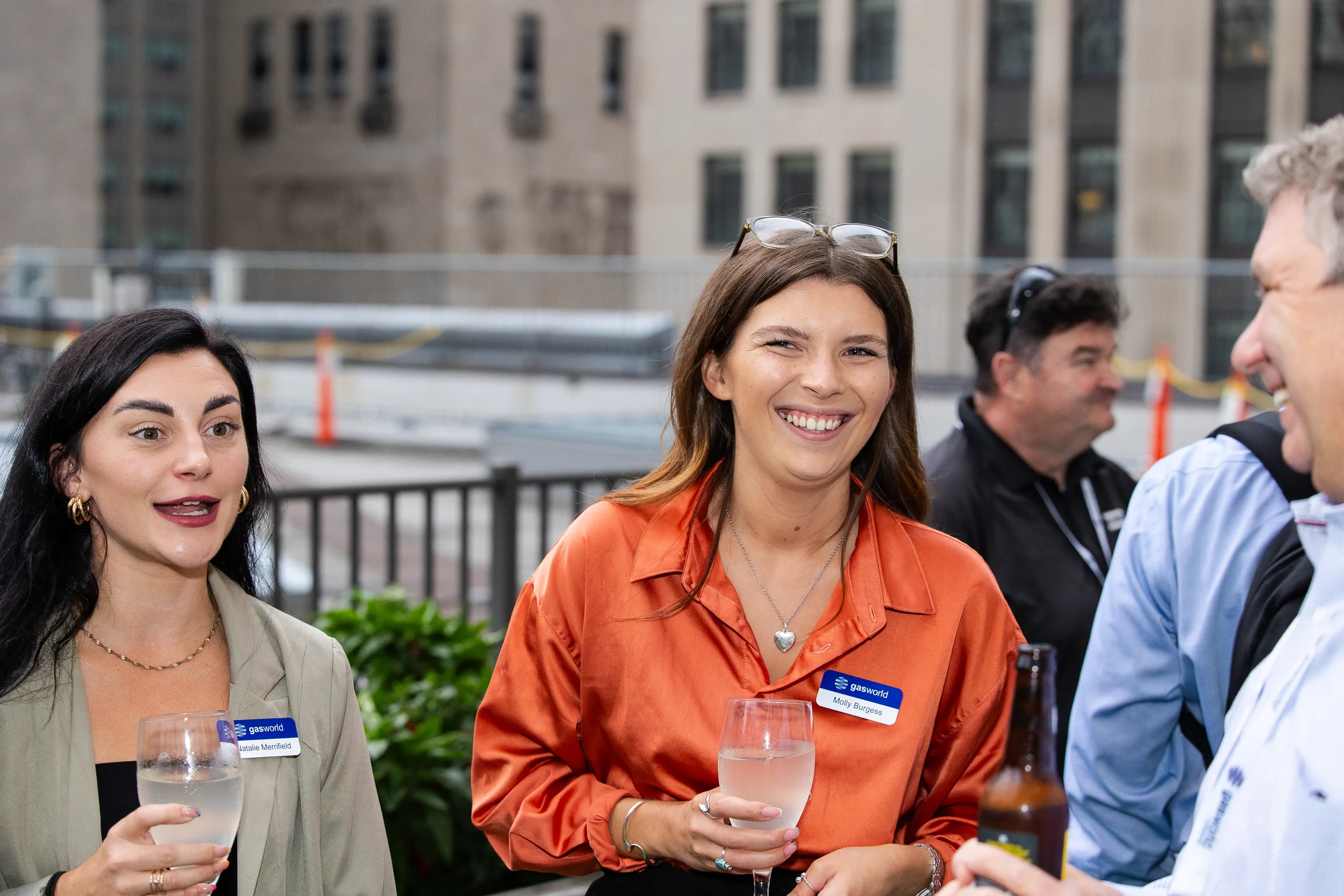 Two attendees laugh together during rooftop reception at Orlando industry conference event