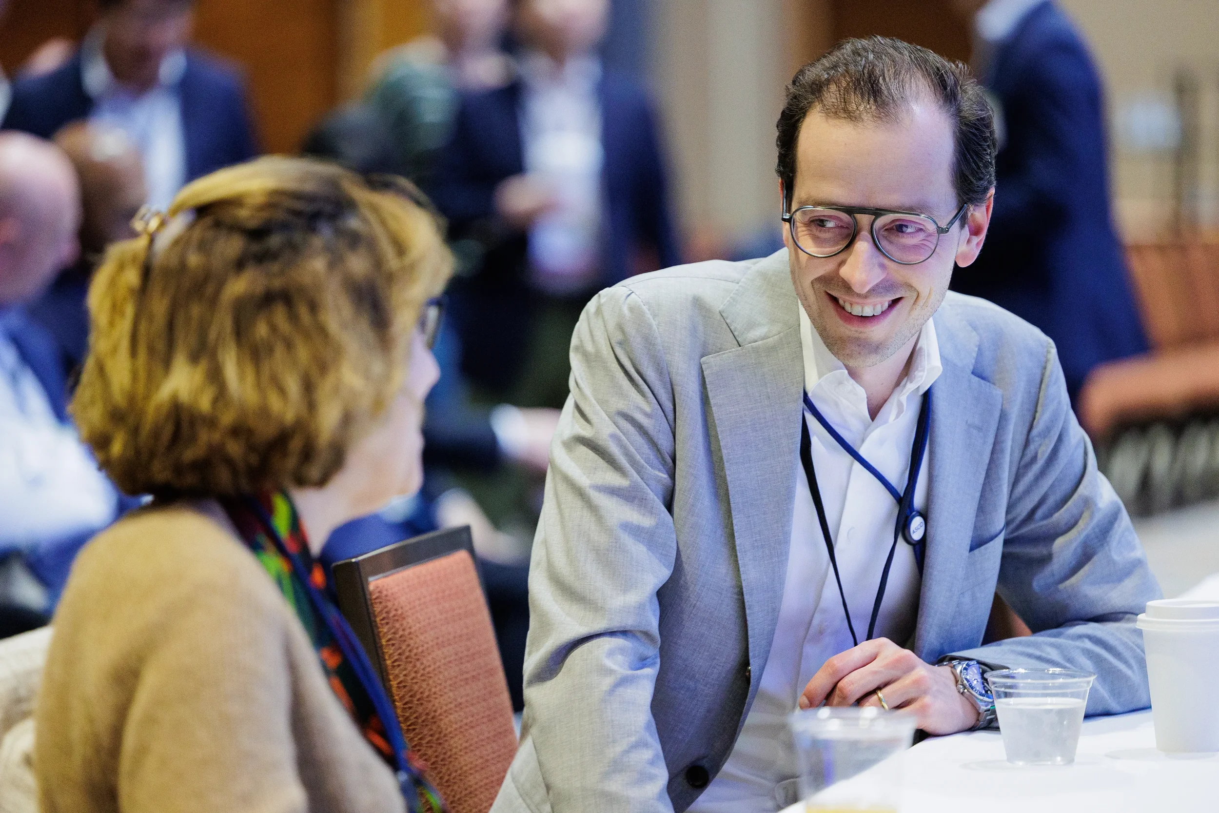Attendee smiles during conversation at seated table during Chicago industry conference