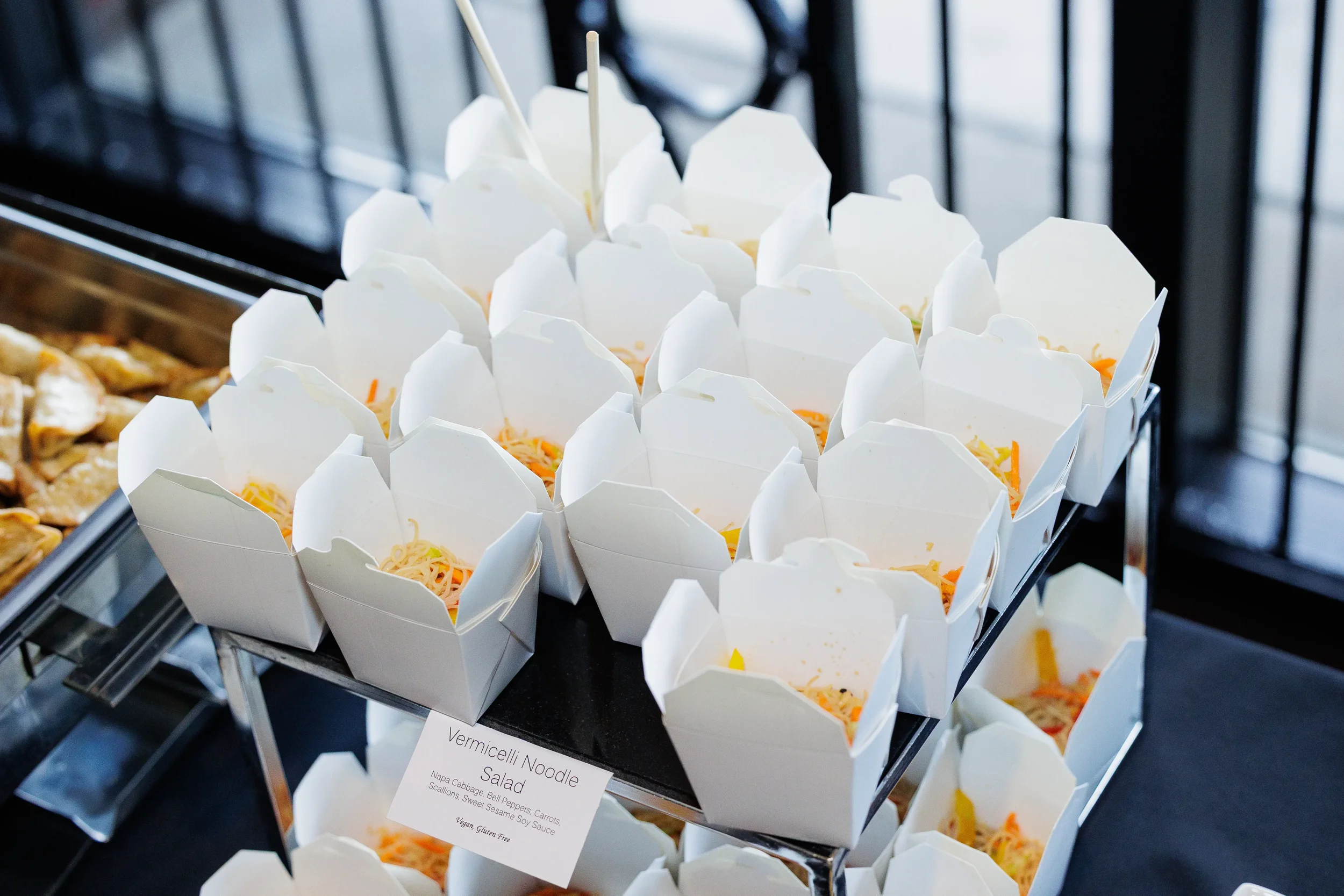 Individual noodle salad boxes displayed on catering table at Orlando corporate event