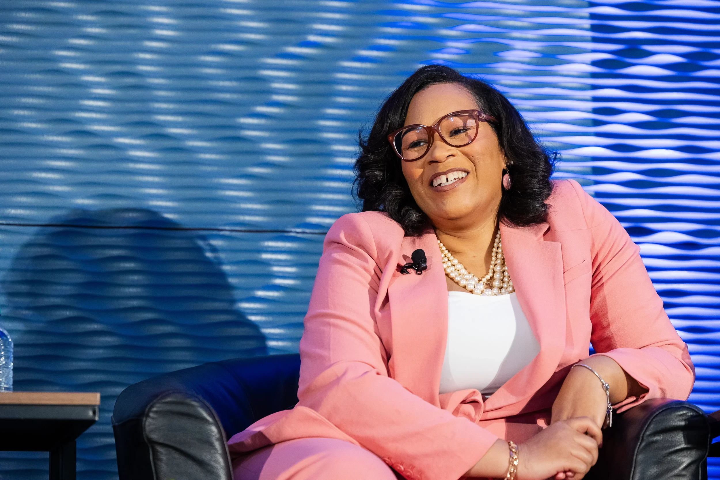 Panelist smiles warmly while seated during panel discussion at Orlando corporate conference