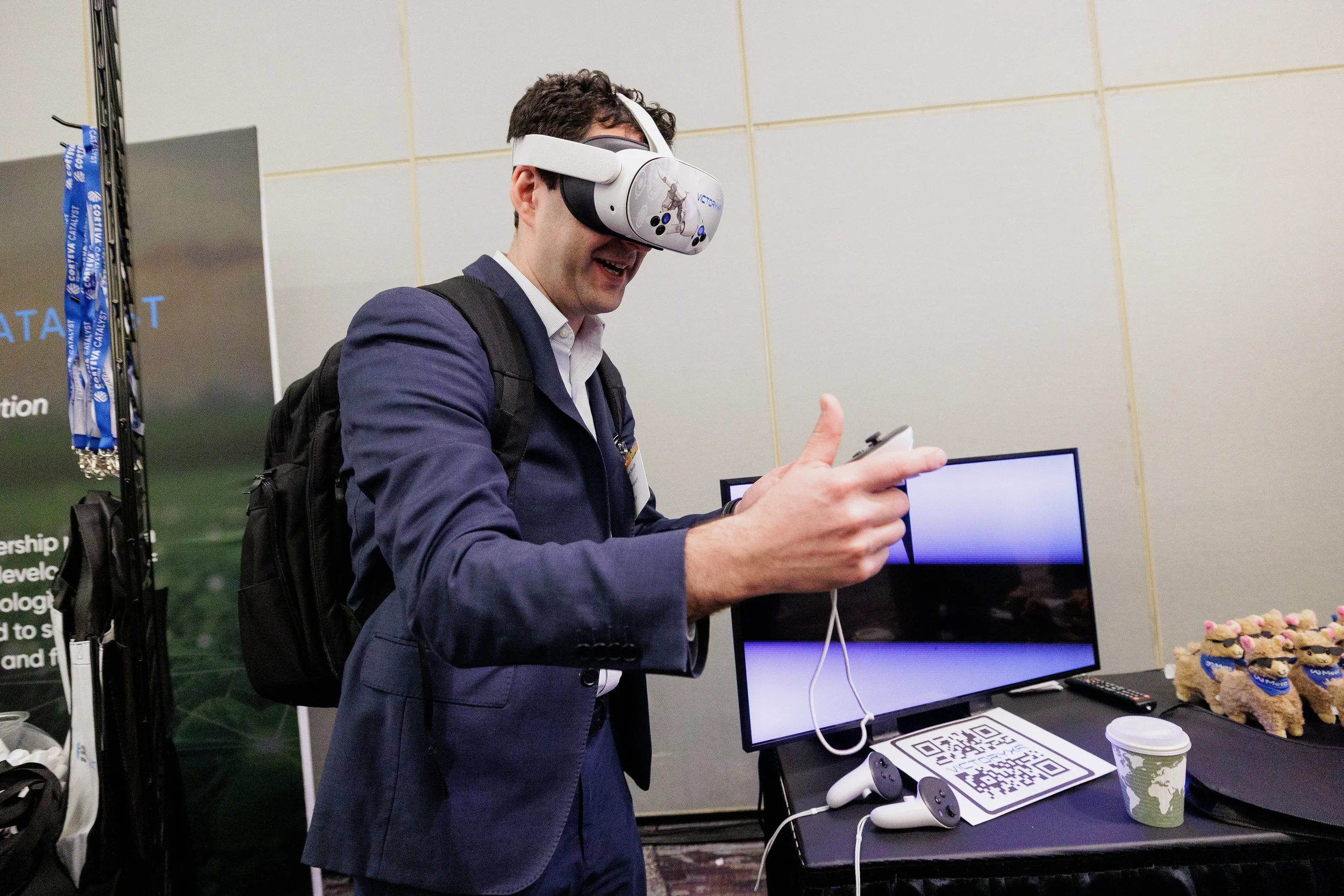 Smiling attendee in suit uses VR headset and controller at exhibitor booth during Orlando corporate conference