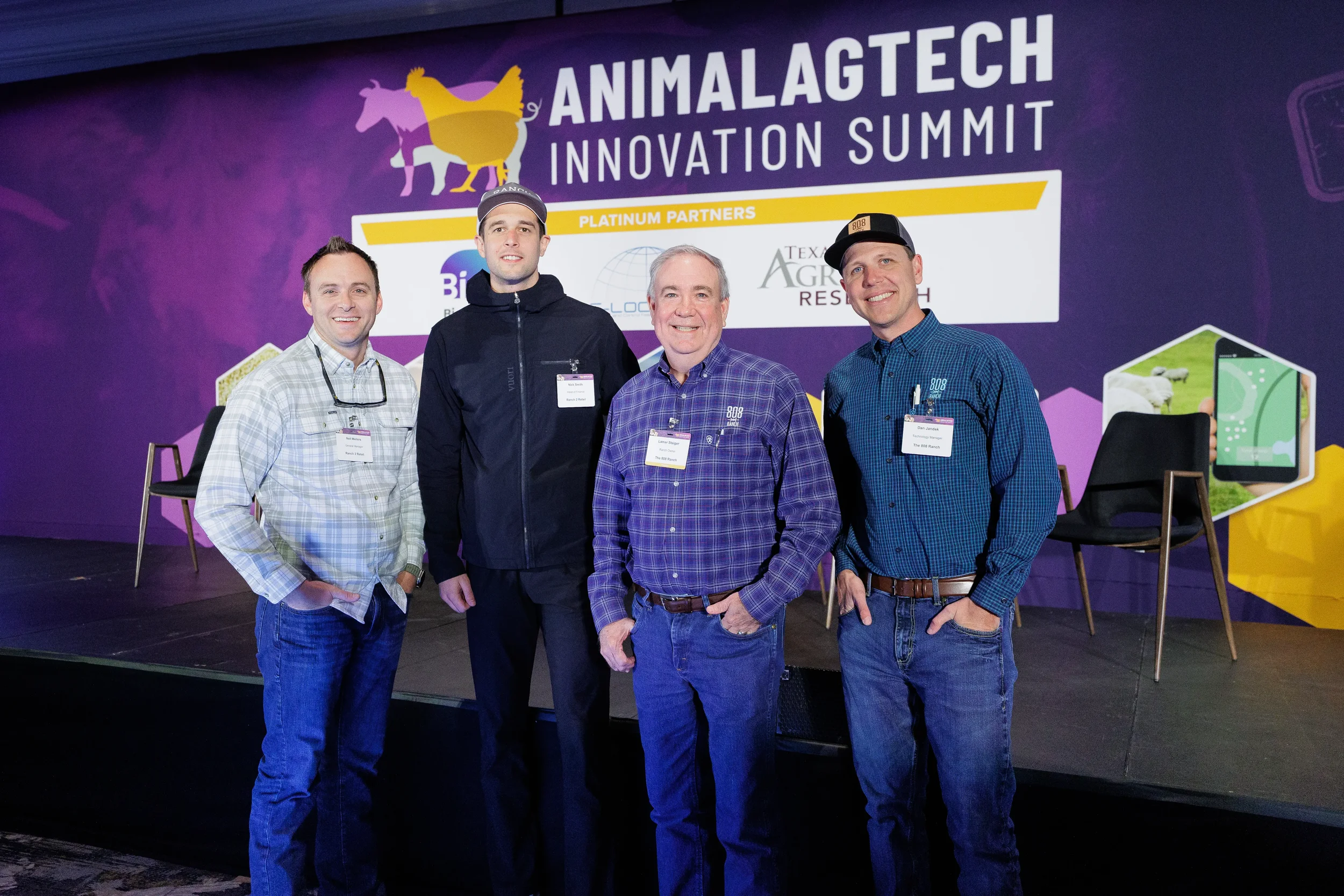 Four attendees pose together on stage in front of event banner at Orlando corporate summit