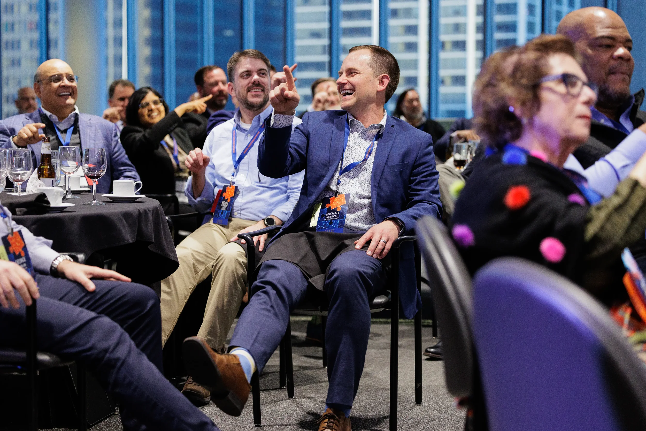 Attendees laugh and point during Chicago corporate conference evening event with city skyline in background