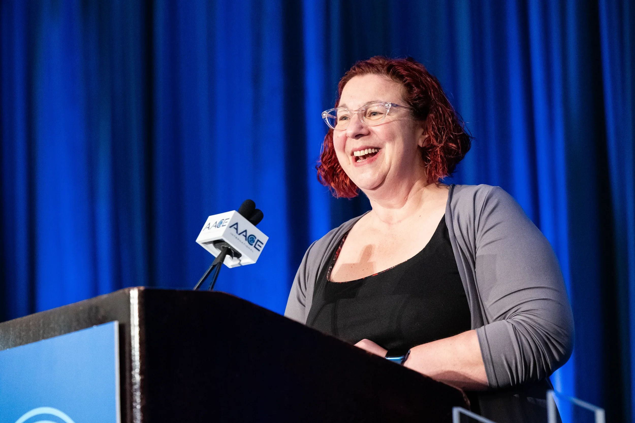 Speaker laughs at podium during presentation at AACE International 2024 in Orlando