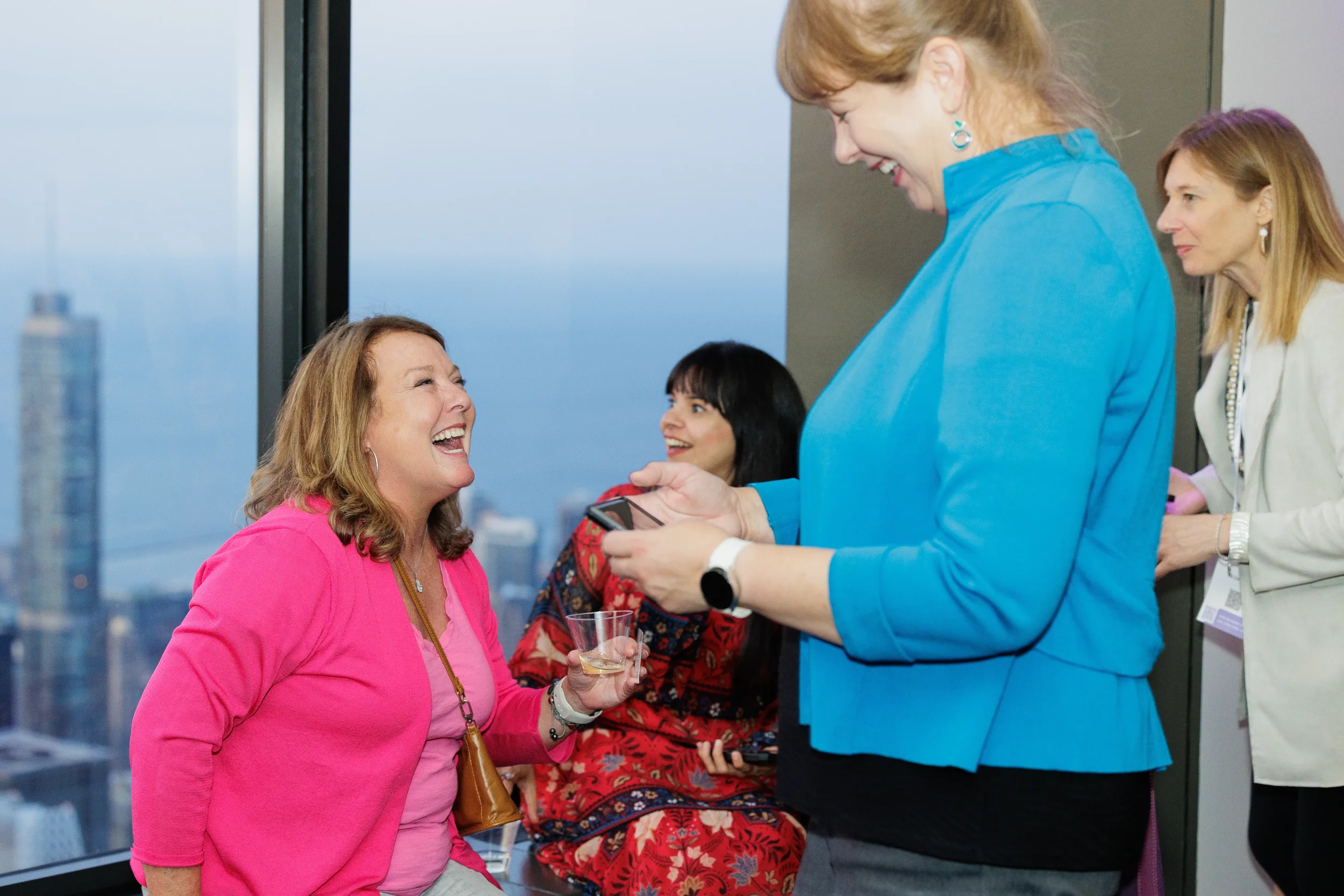 Attendees laugh together with skyline view during Chicago corporate event reception