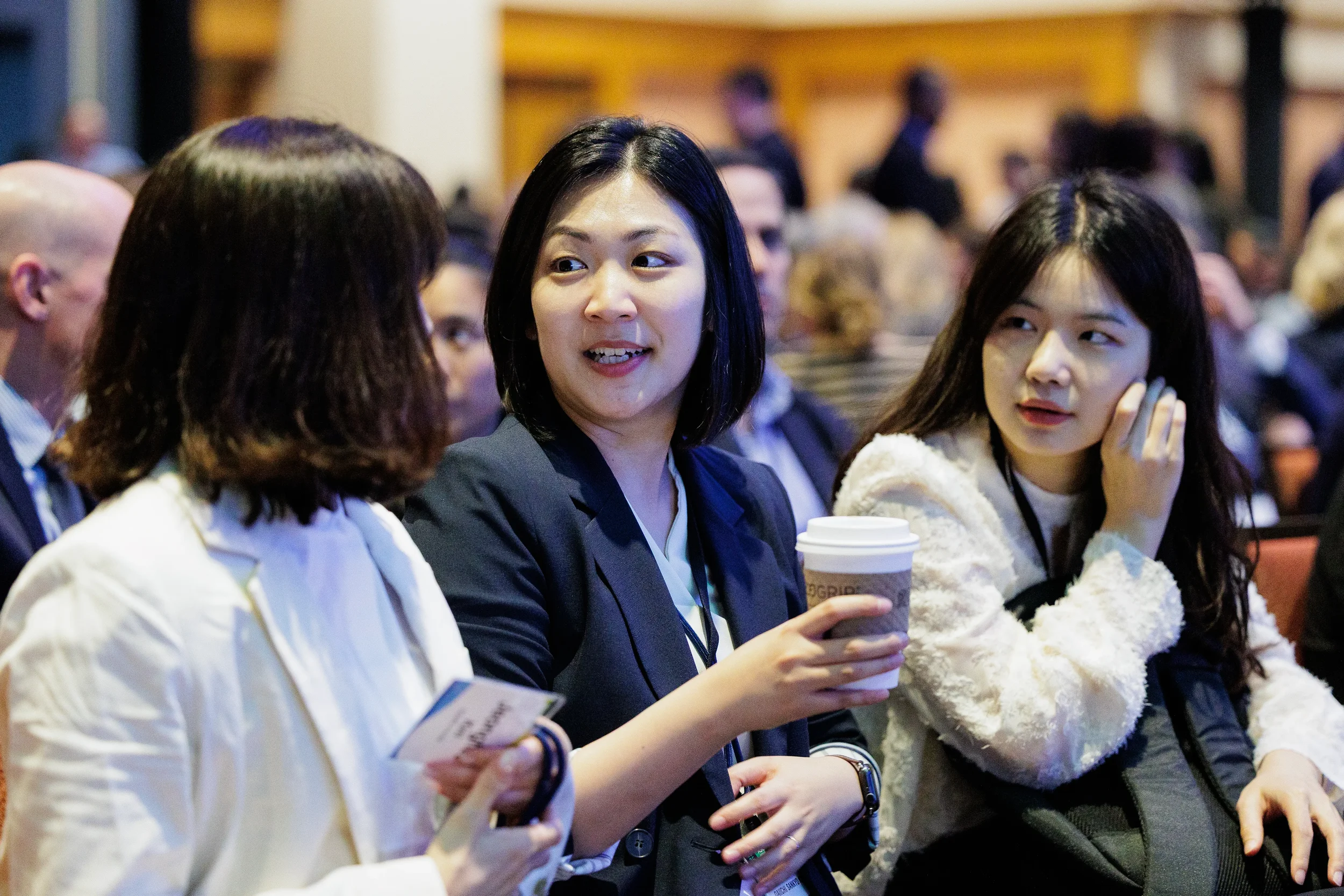 Attendees chat while seated with coffee before session at Chicago corporate conference