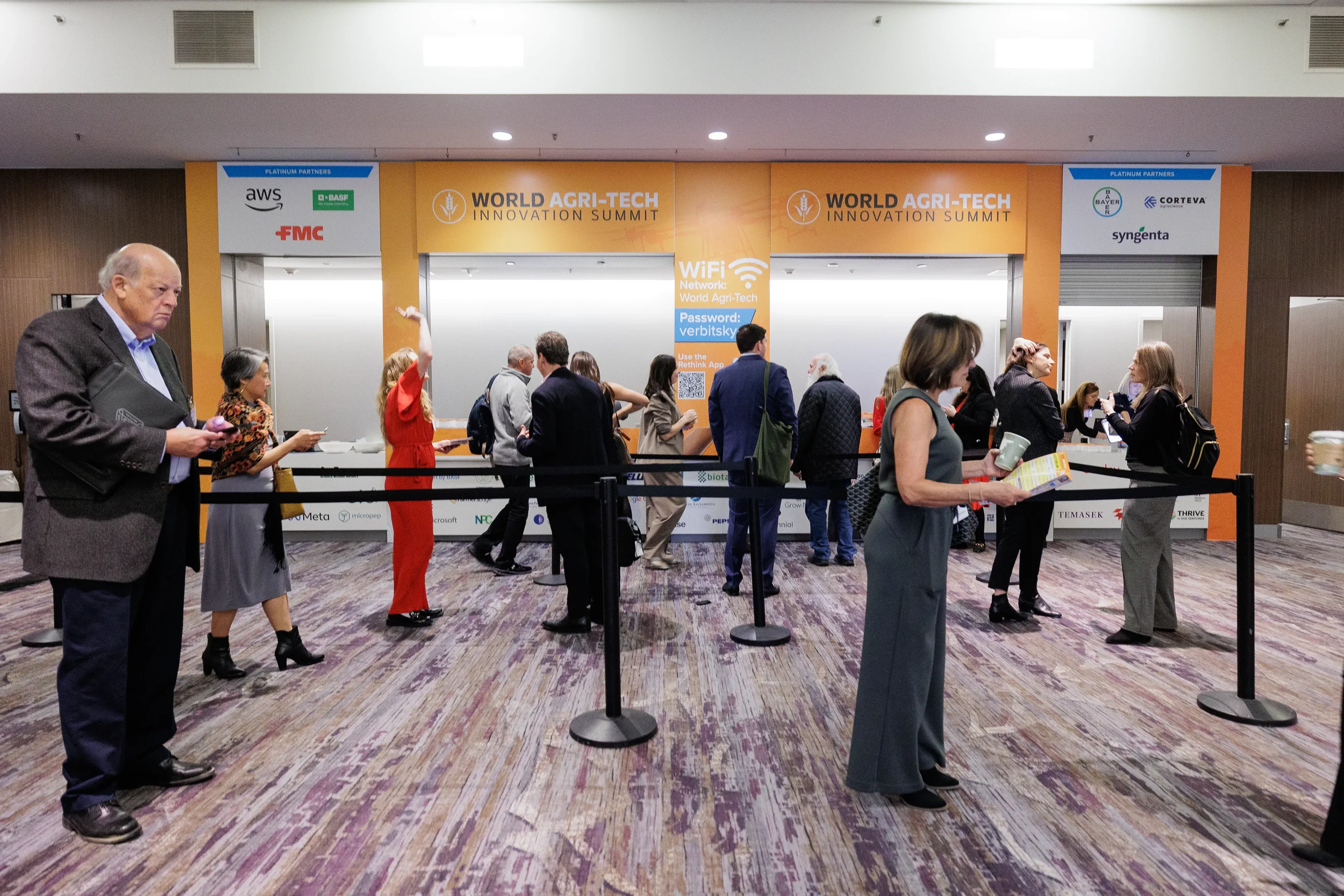 Attendees queue at registration desk beneath branded signage at Orlando industry conference entrance