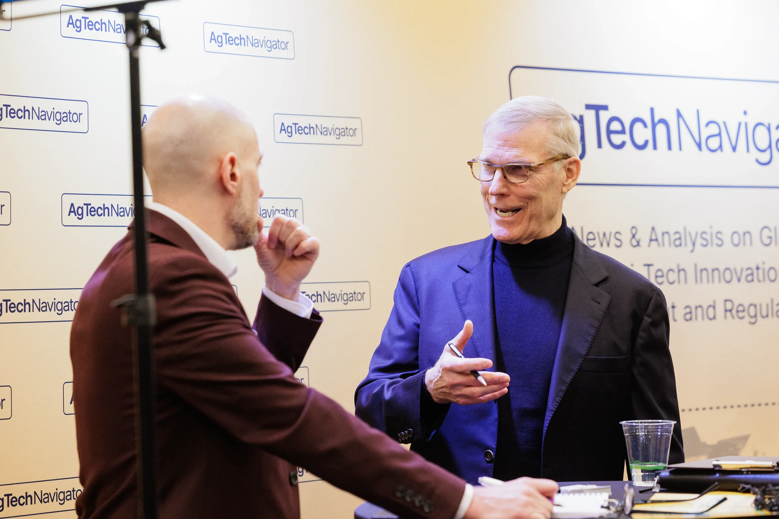 Two attendees converse in front of branded media backdrop at Orlando corporate industry conference