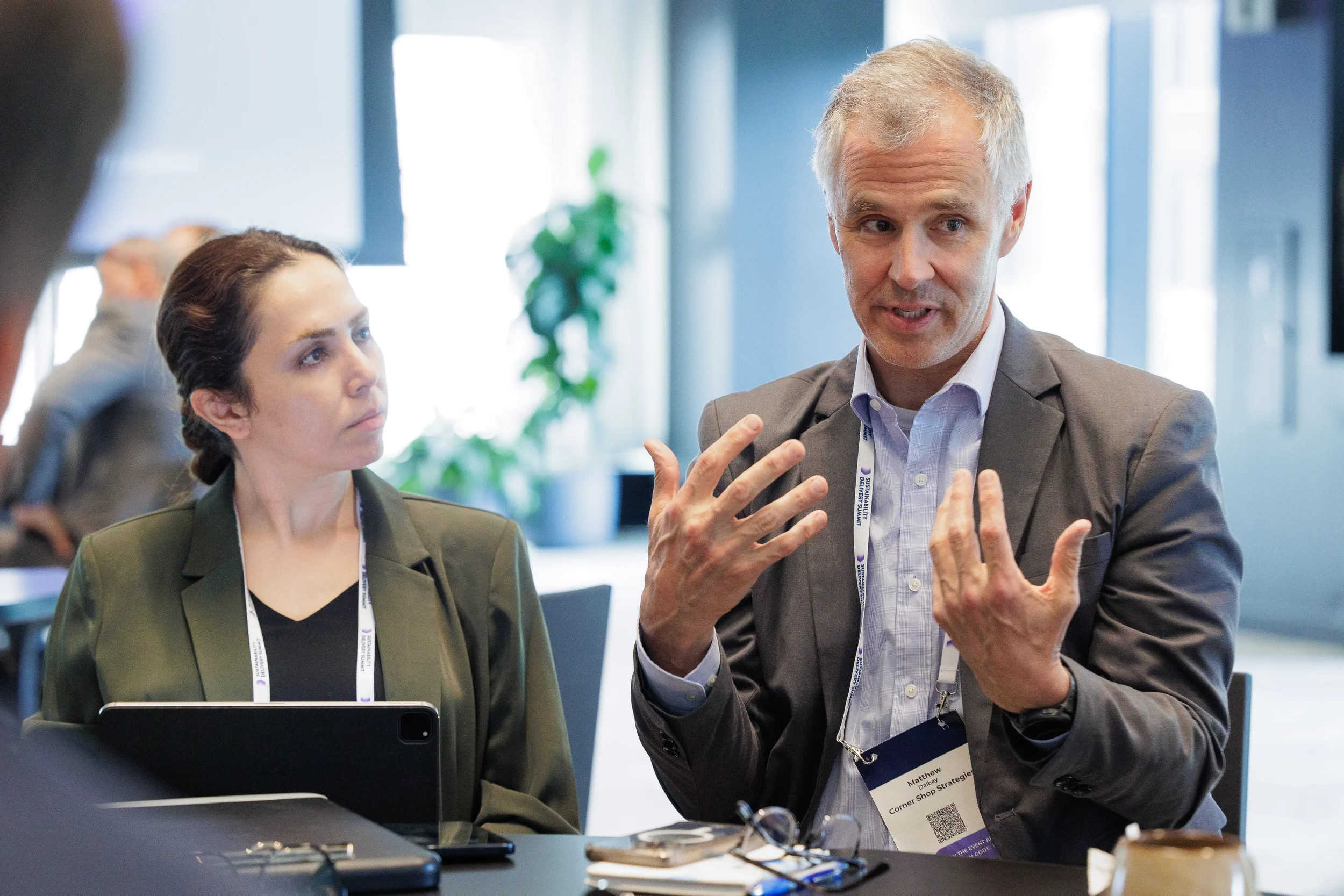 Attendee gestures while speaking during seated conversation at Chicago corporate conference