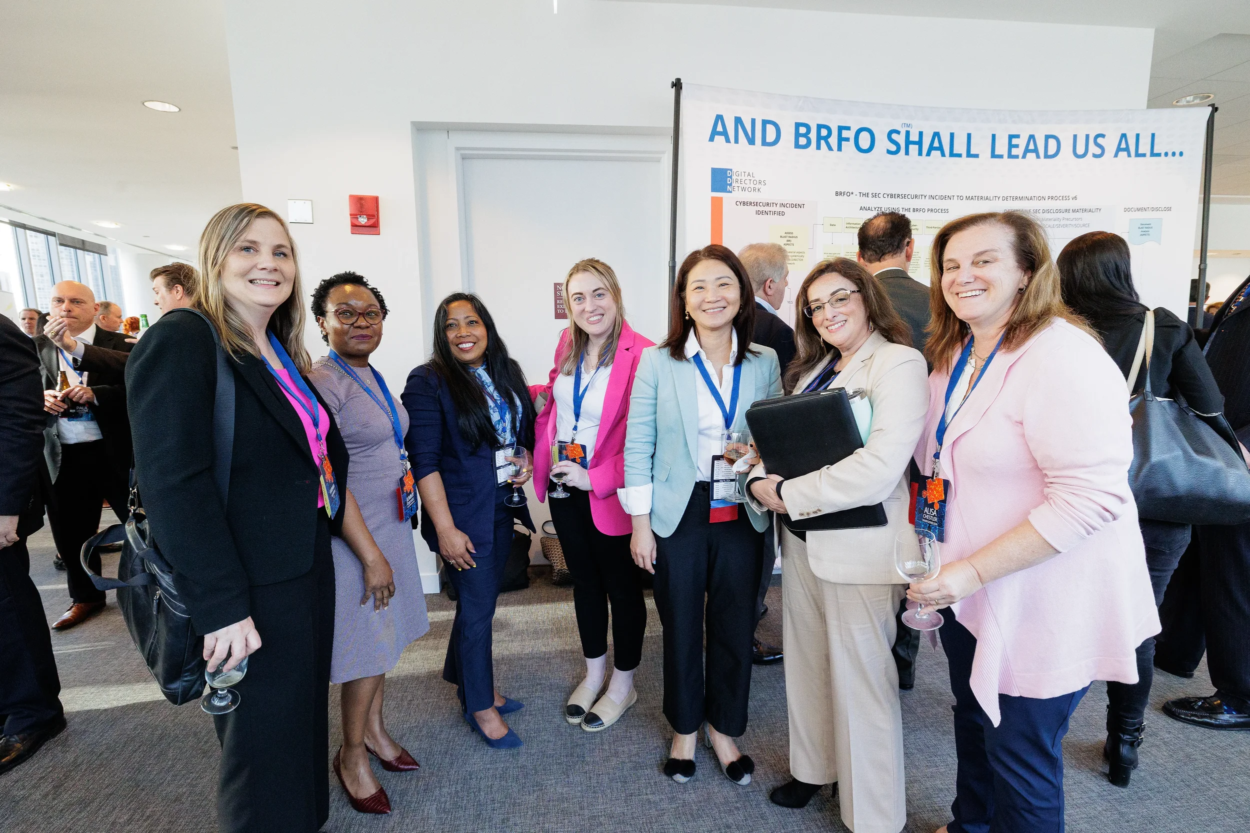Group of female attendees with lanyards pose together during Orlando corporate conference networking reception