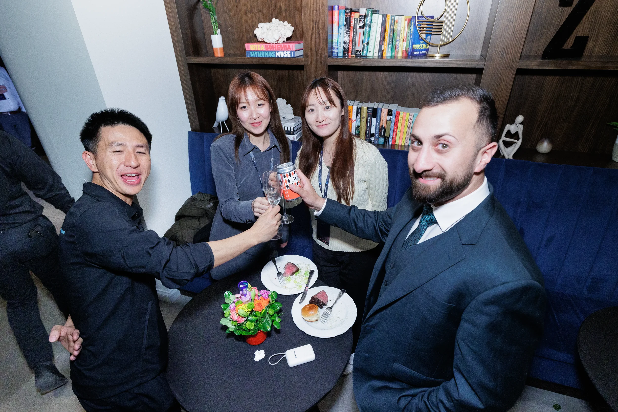 Four attendees toast with drinks at lounge table during Orlando corporate event reception