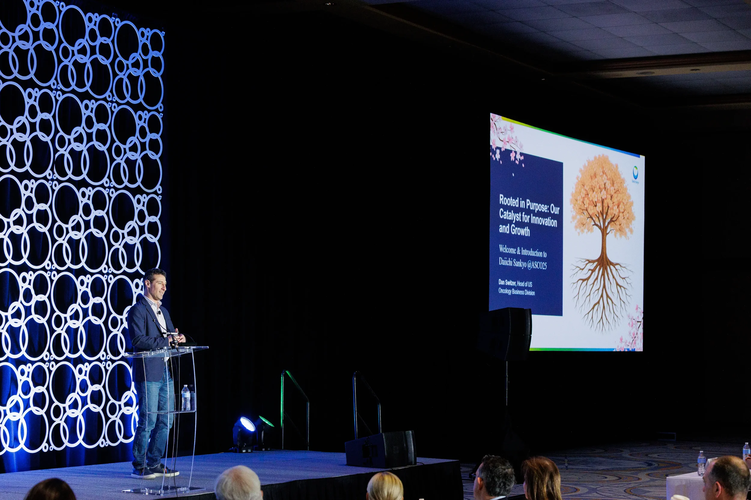 Speaker presents from podium on branded stage at Chicago corporate conference