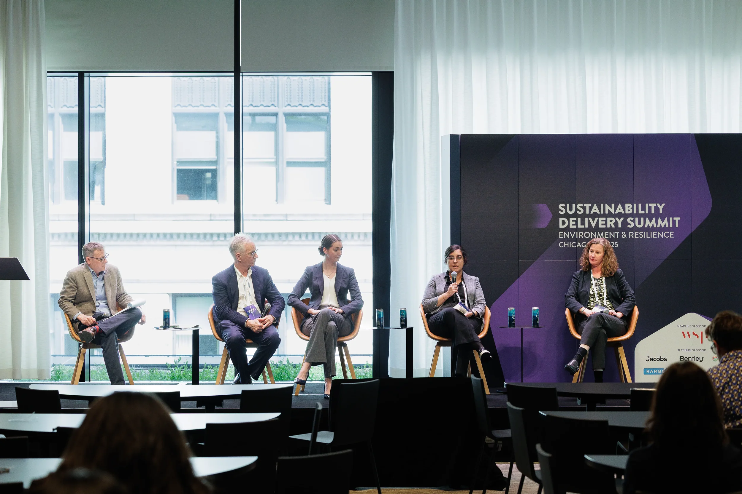 Five panelists seated on stage with microphones during Chicago industry conference discussion