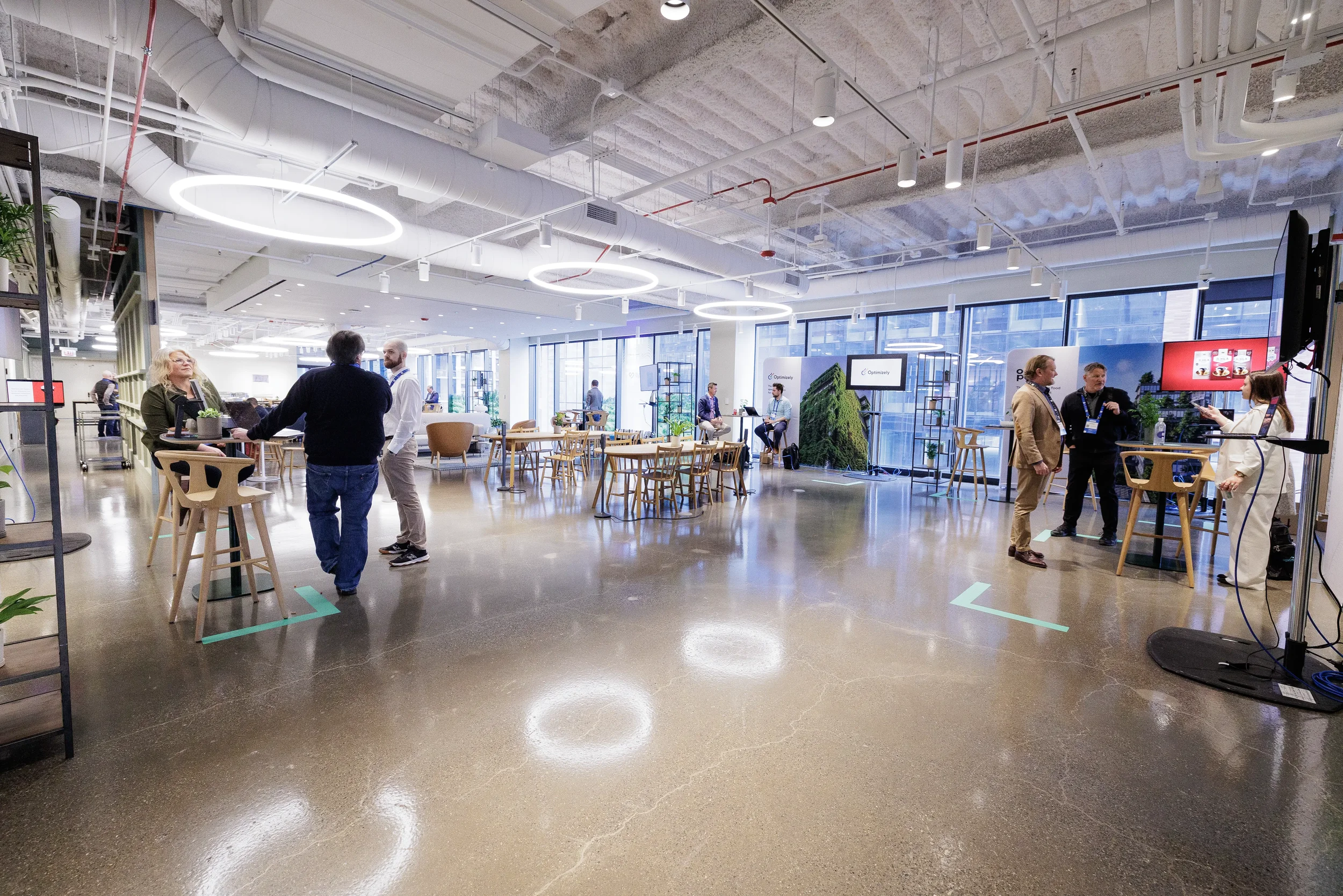 Attendees mingle at high tables in modern networking lounge with ring lights at Orlando corporate event