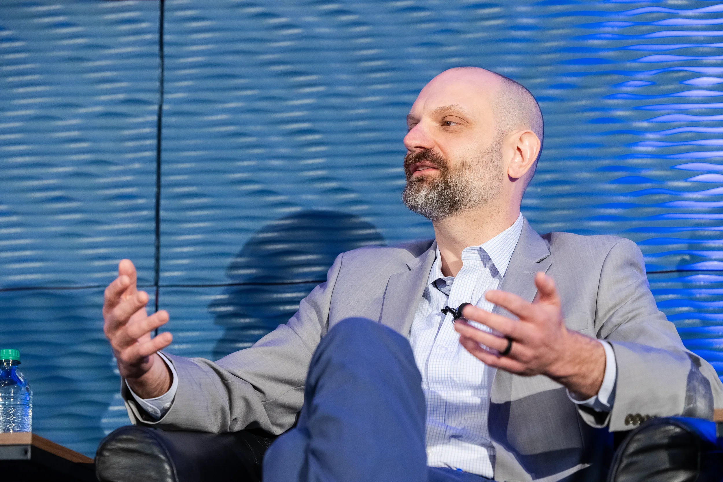 Panelist gestures while speaking during fireside chat on stage at Chicago industry conference