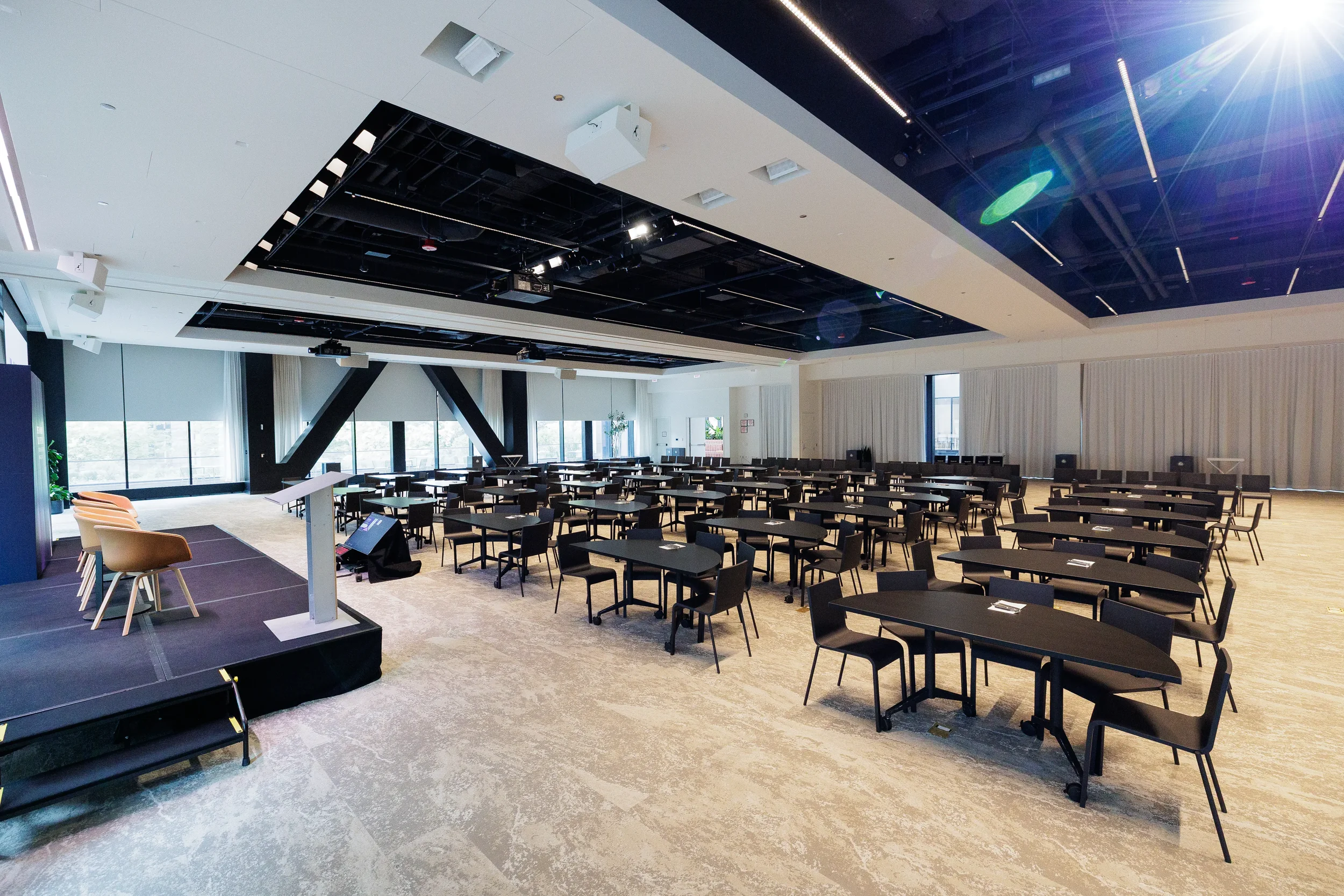 Conference hall set with tables and stage ahead of Chicago corporate summit session