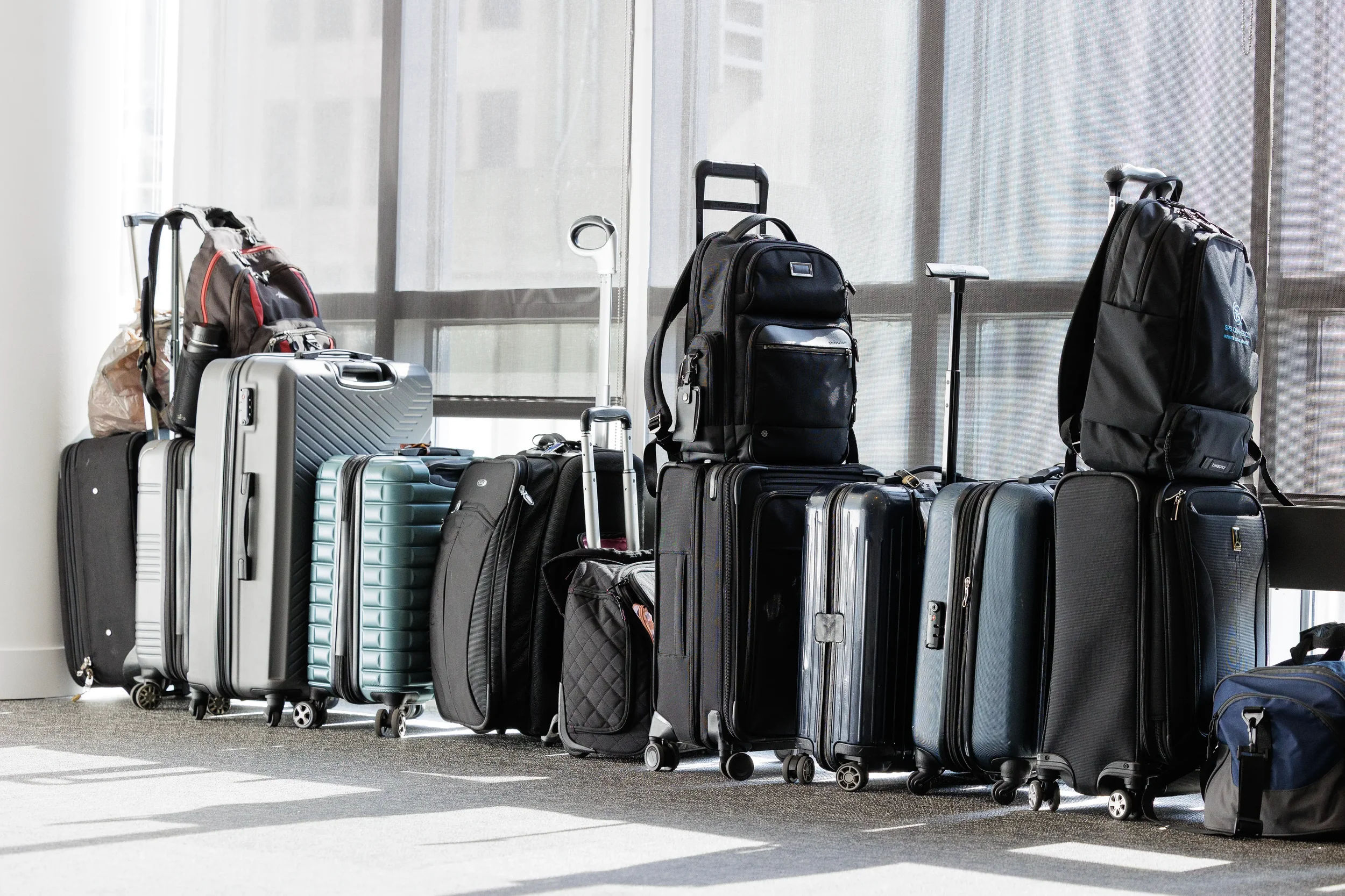 Rows of attendee luggage and backpacks lined against windows at Chicago corporate conference venue