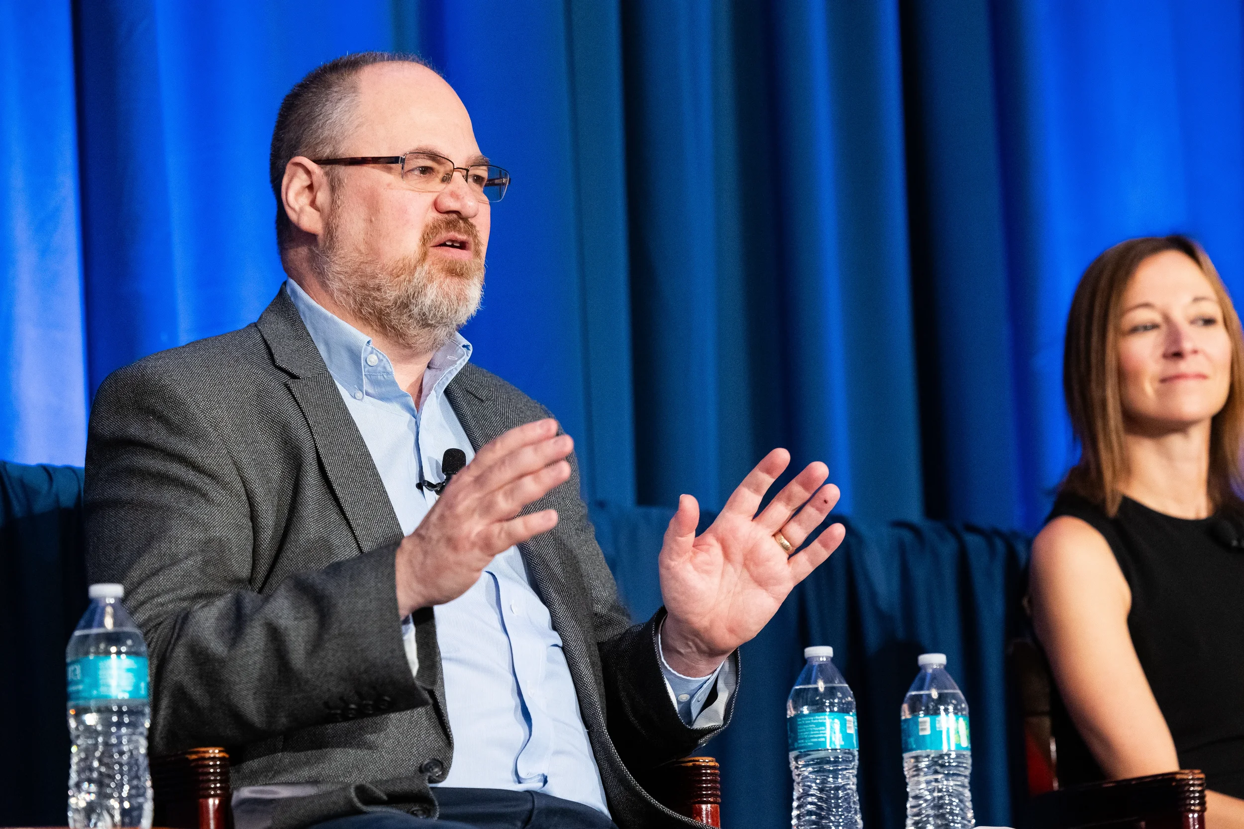 Panelist gestures while sharing insights during AACE International conference session in Orlando