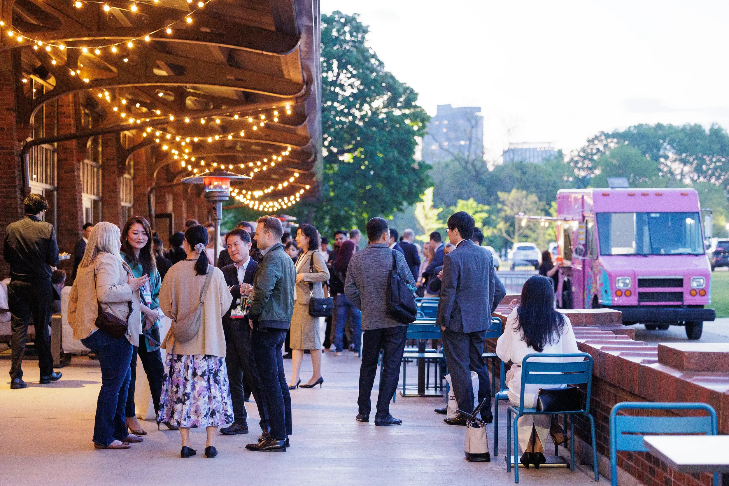 Attendees network under string lights during Chicago corporate event evening reception