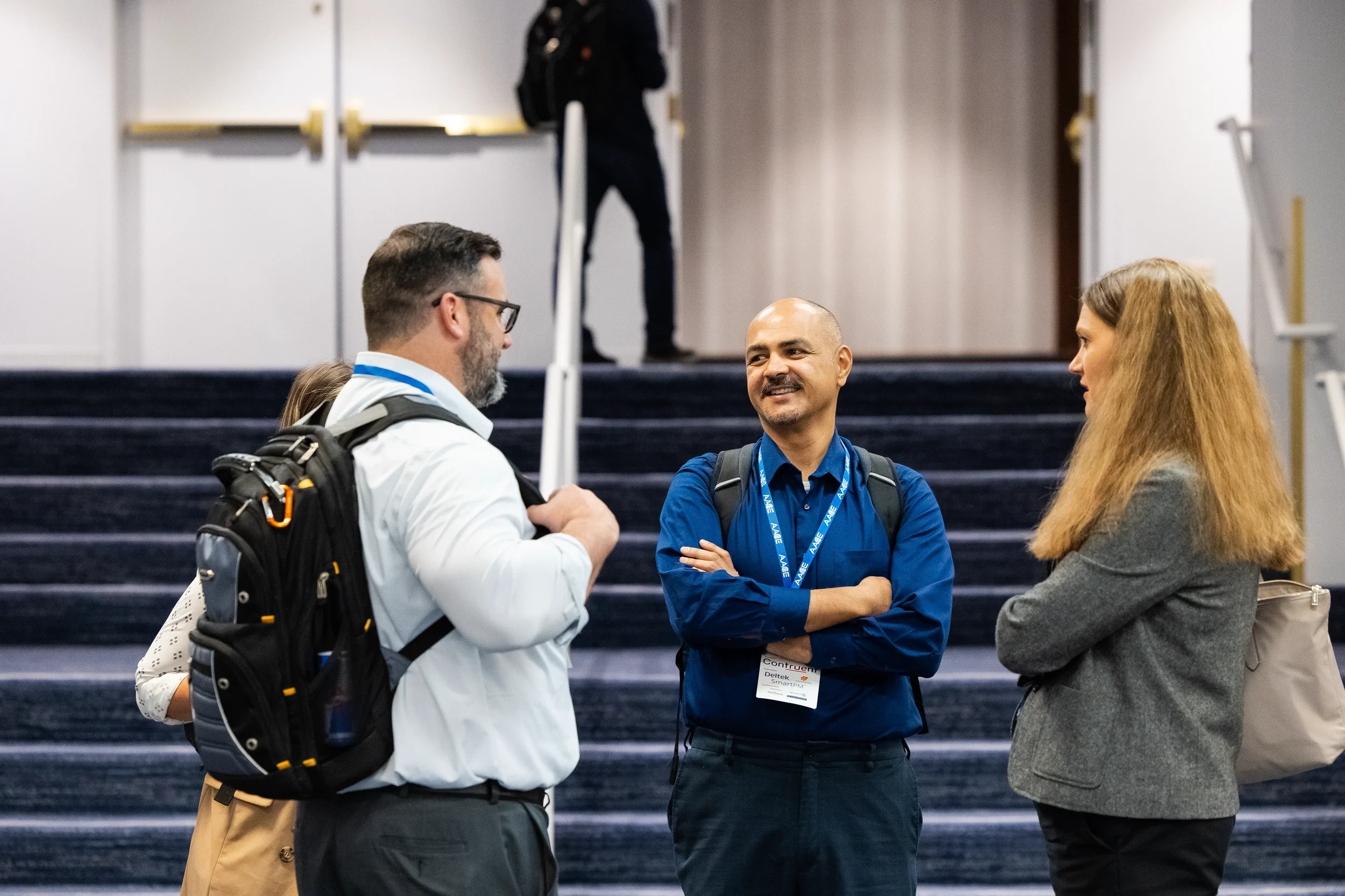Three conference attendees networking in hallway between sessions at Chicago event