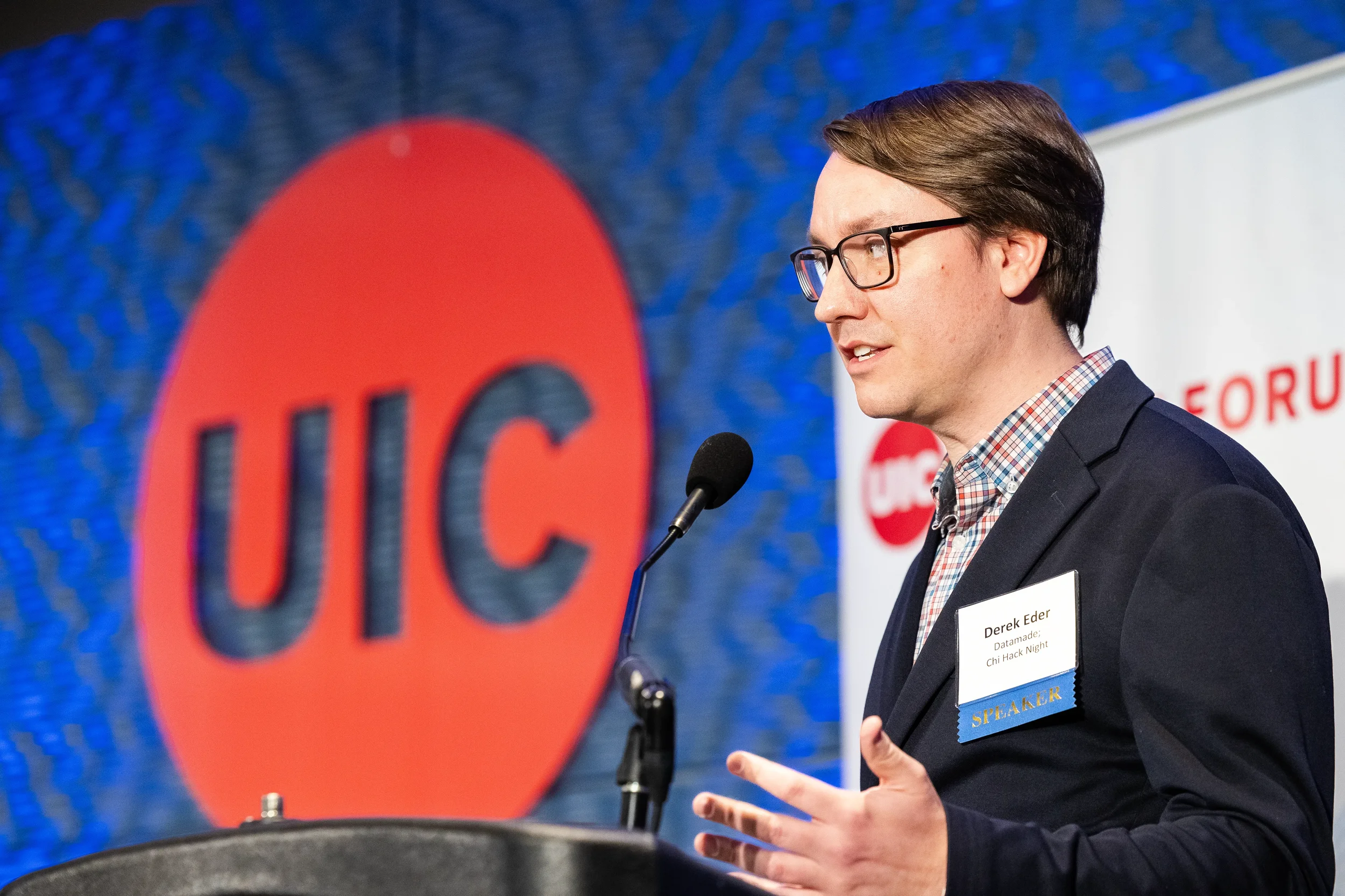 Speaker gestures while presenting from podium on stage at Orlando industry conference