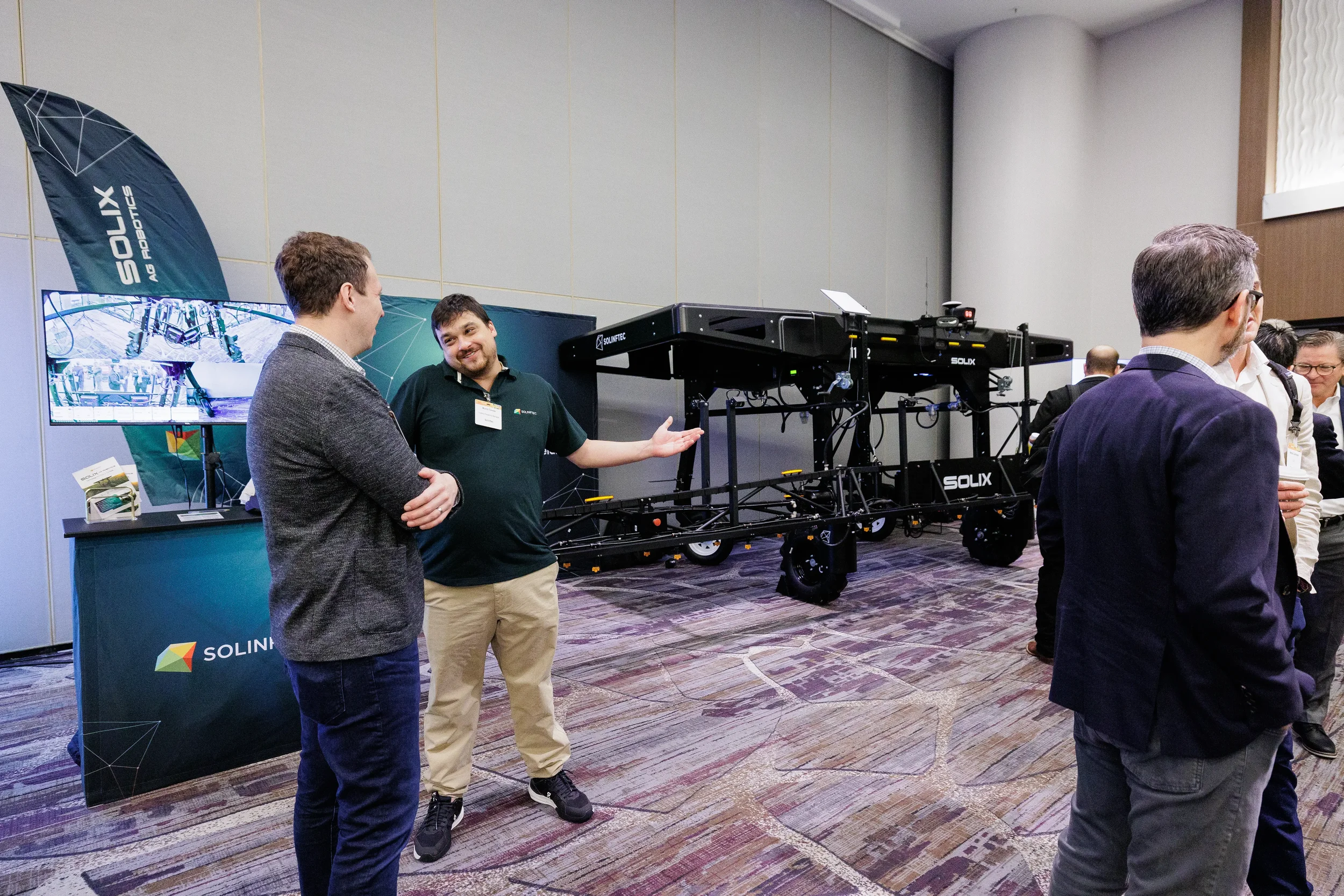 Exhibitor demonstrates agricultural robotics equipment to attendees on Chicago conference trade show floor