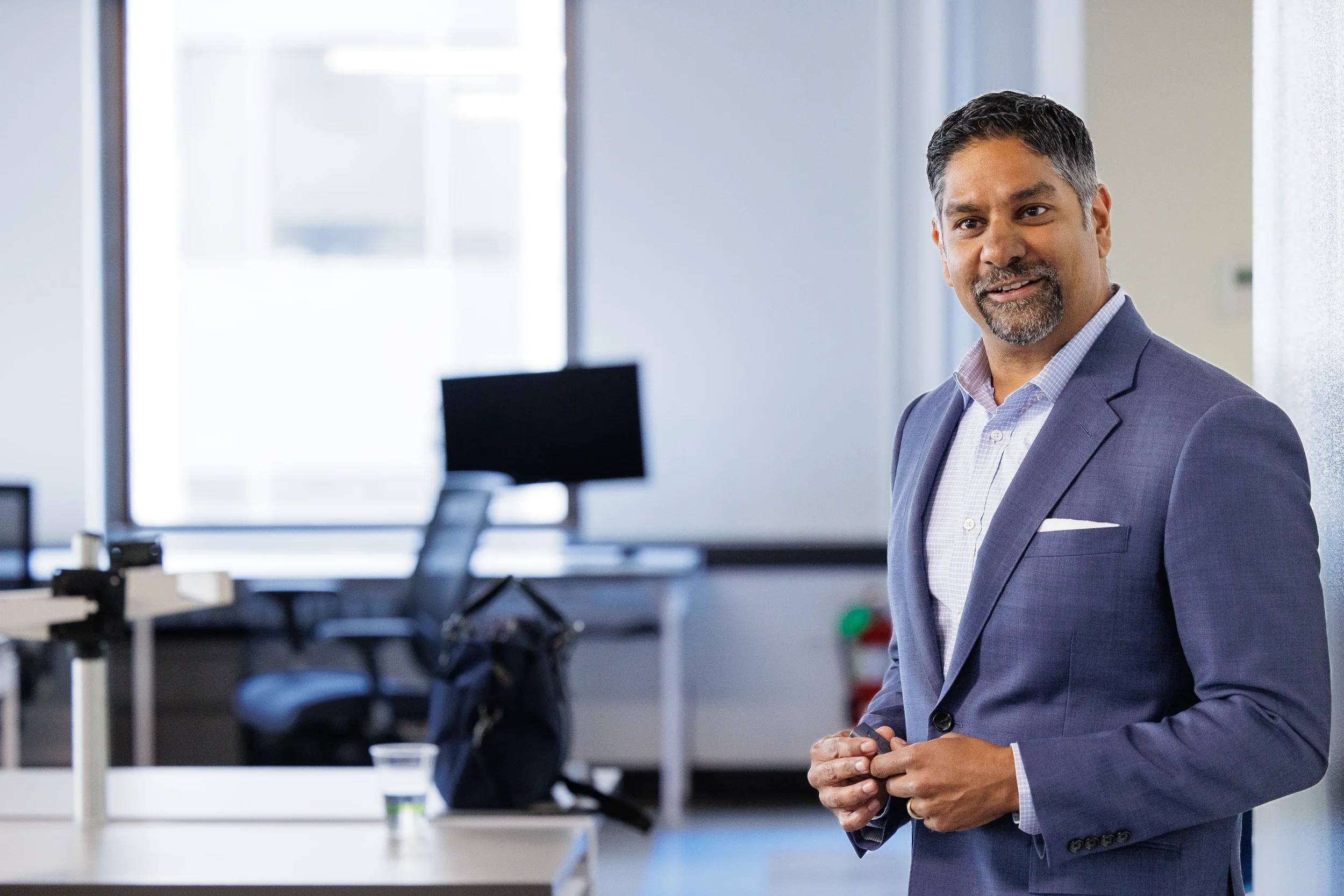 Confident male speaker smiles in a bright modern event space at Chicago industry conference