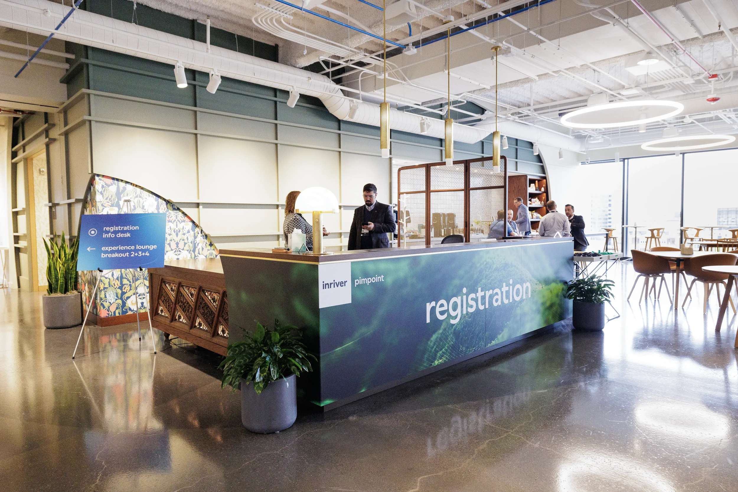 Branded registration desk with directional sign and lounge seating at Chicago corporate conference