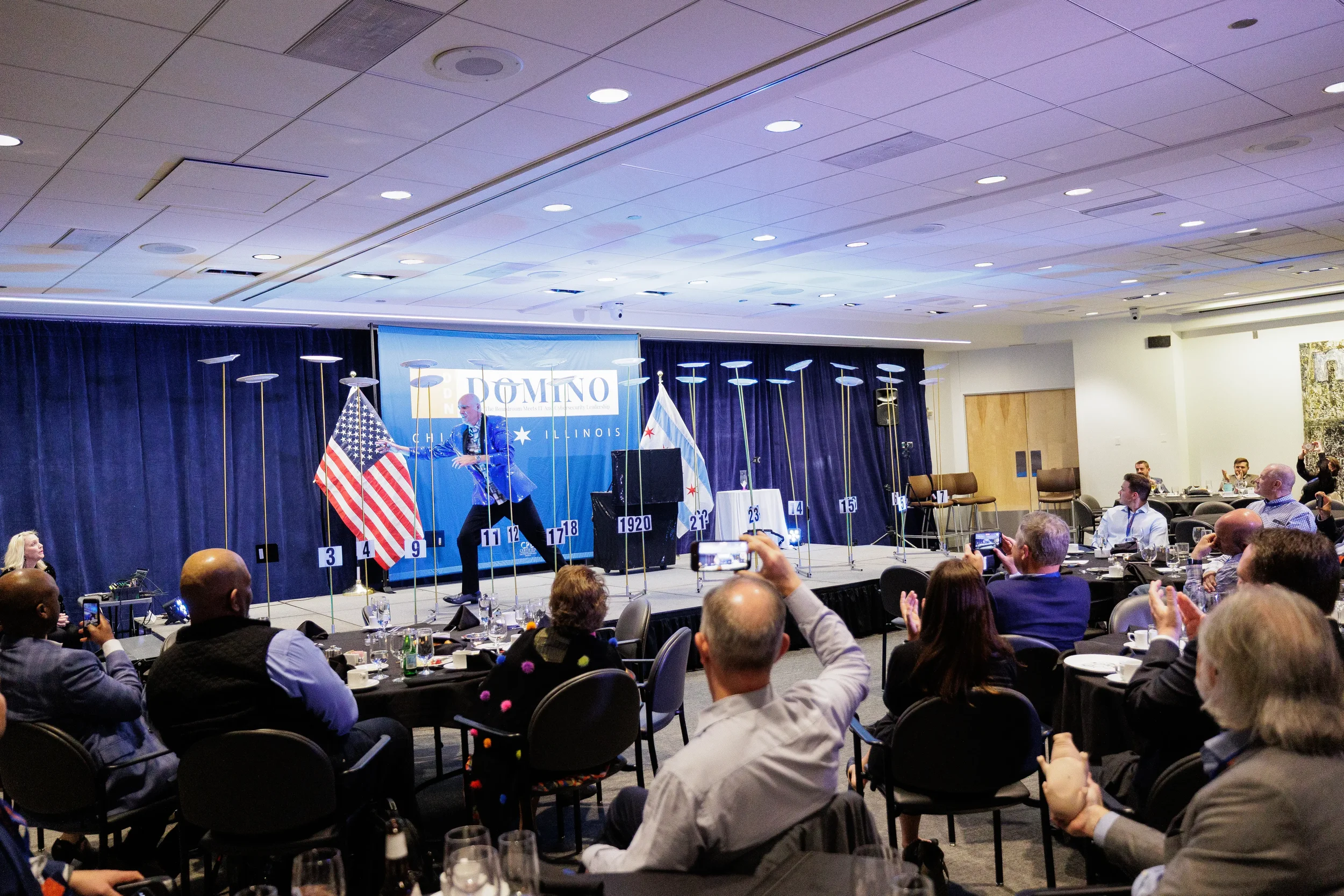 Performer spins plates on stage before engaged audience at Chicago corporate conference event